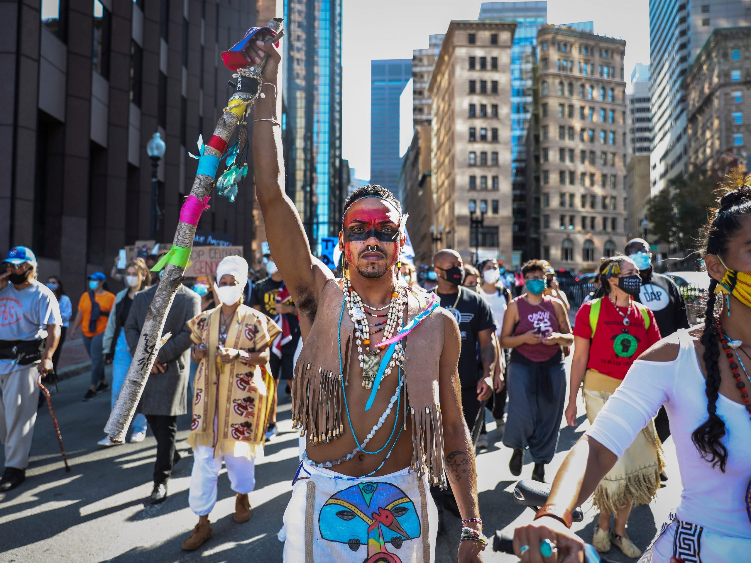 A demonstrator marches to Faneuil Hall with other protesters while participating in the Indigenous Peoples Day rally and march in Boston on Oct. 10, 2020.