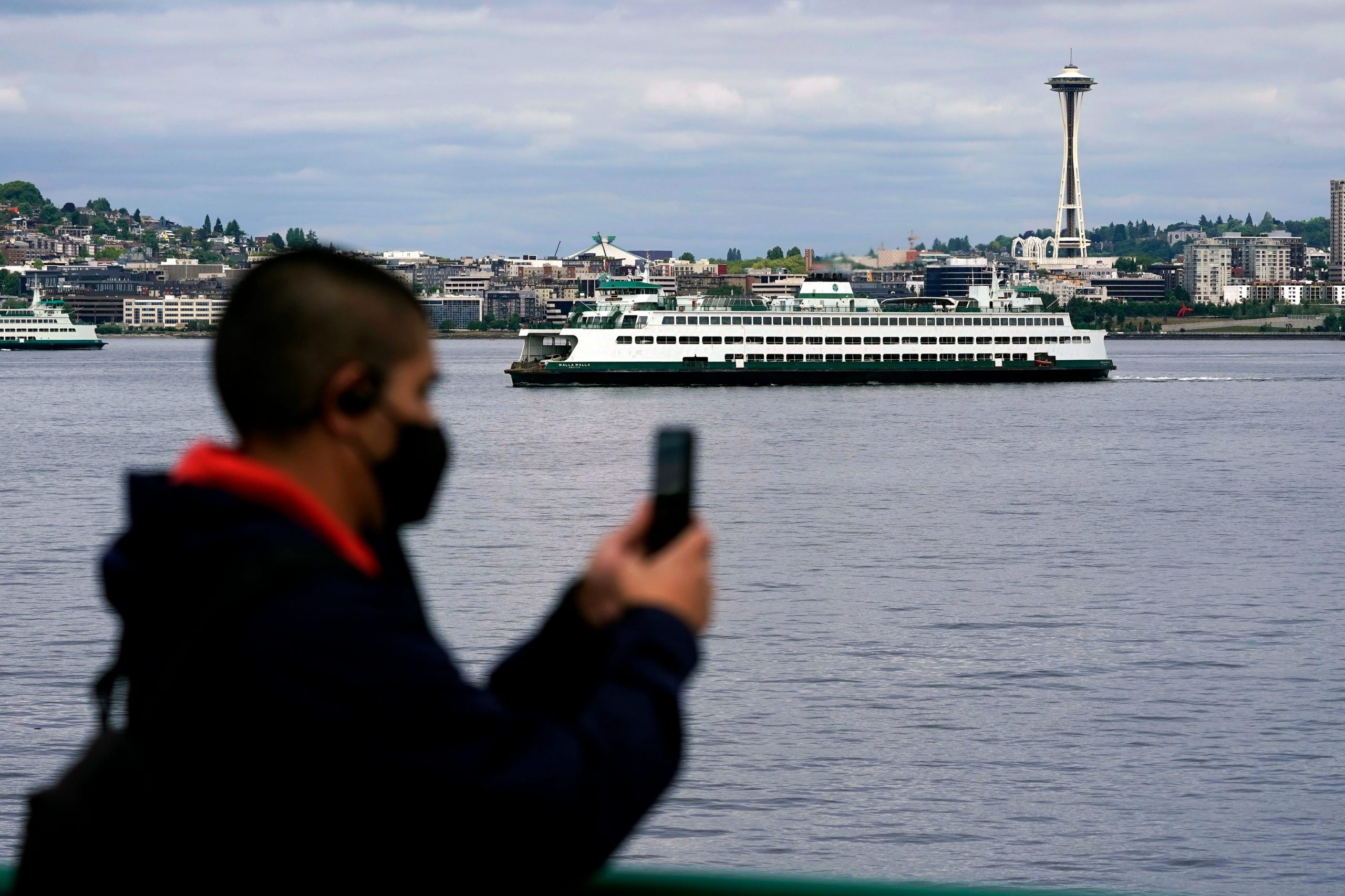 A passenger on a Washington state ferry with the Space Needle behind him