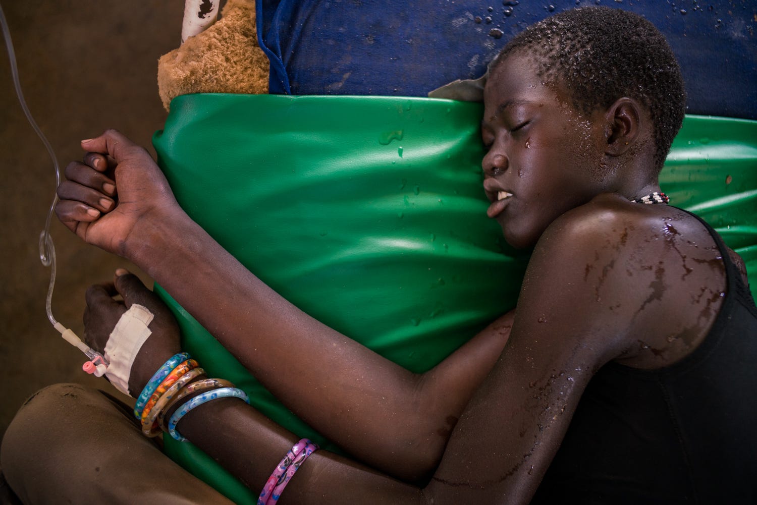 A patient lies on his side as he receives intravenous treatment.