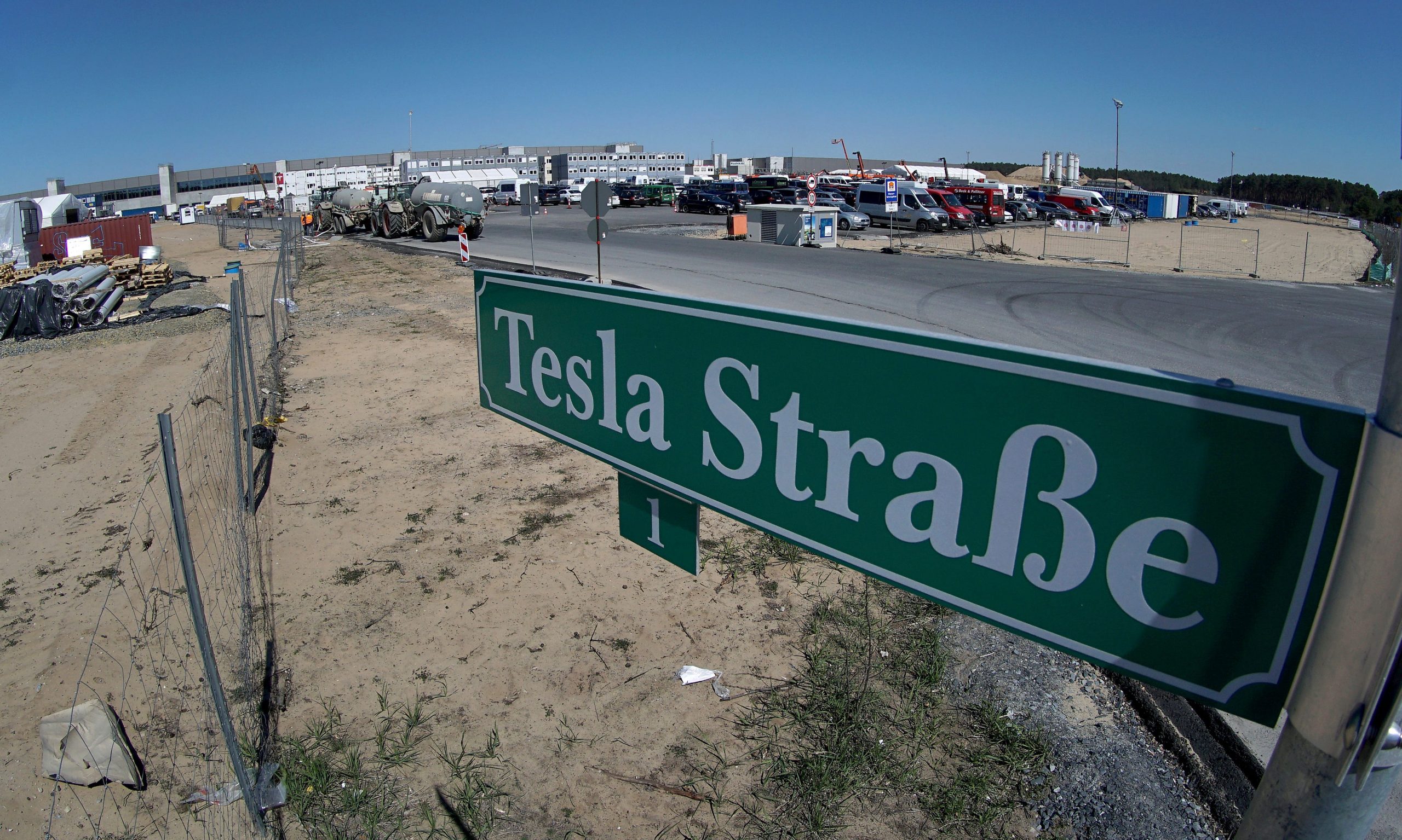 A green street sign outside the new Tesla Gigafactory in Berlin says Tesla Strasse, or Tesla Road