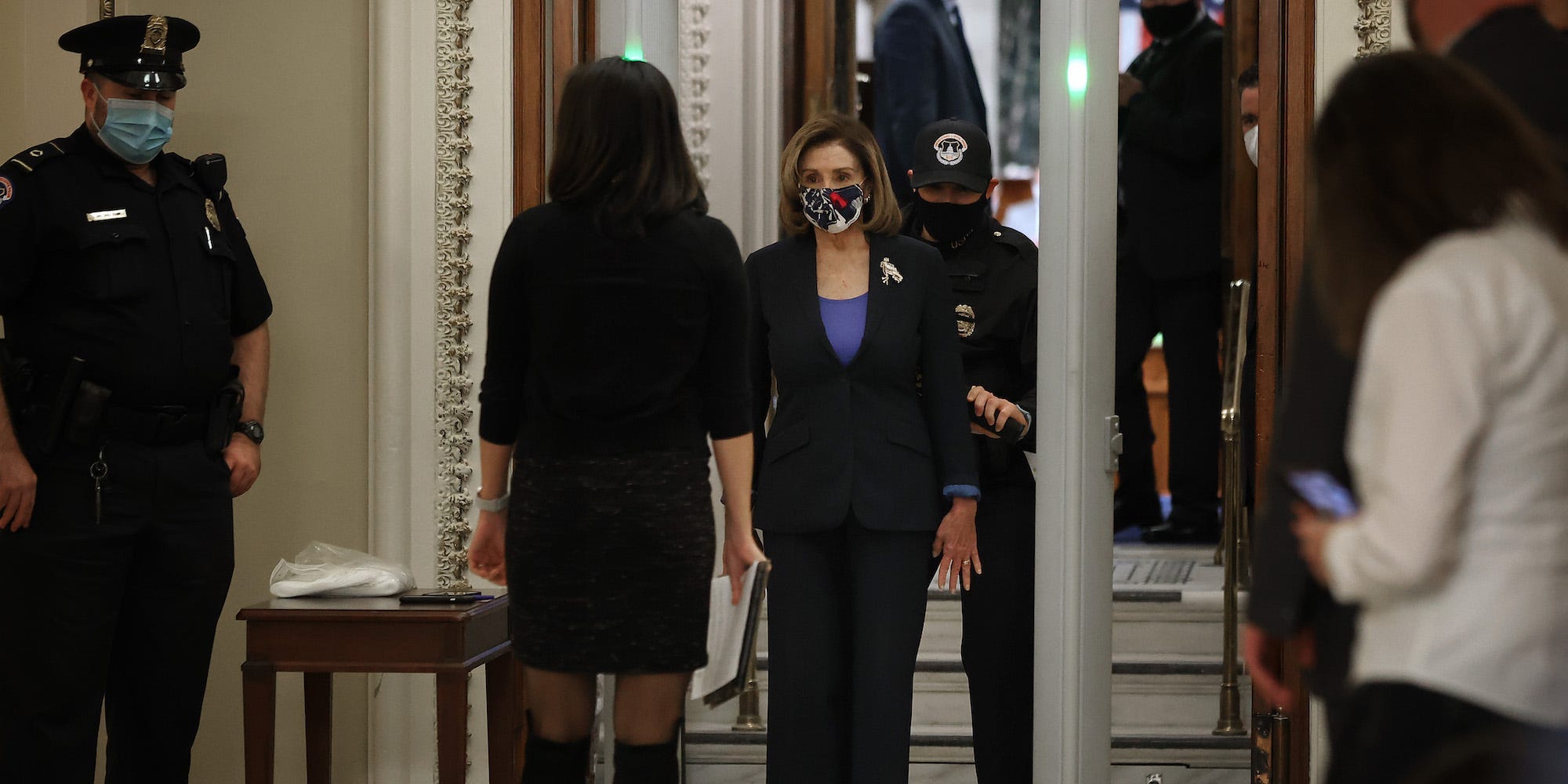 Speaker of the House Nancy Pelosi is screened at a metal detector at the doors of the House of Representatives Chamber on January 12, 2021.