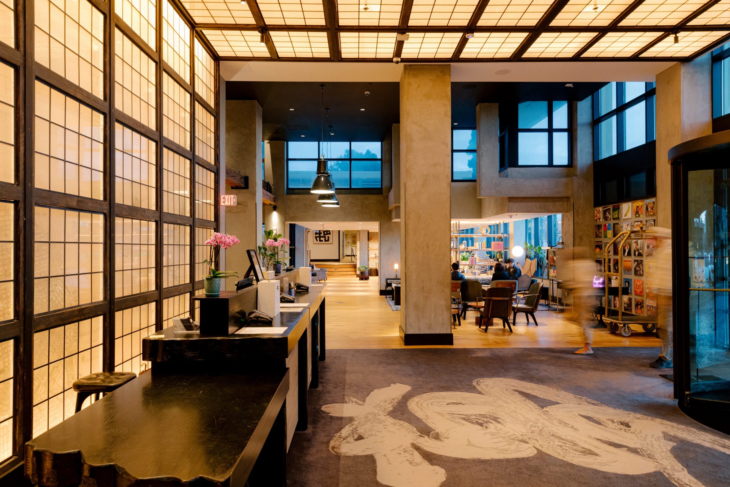 The front desk of Hotel Kabuki in San Francisco's Japantown, which is decorated with paneled walls and a ceiling, as well as warm colors.