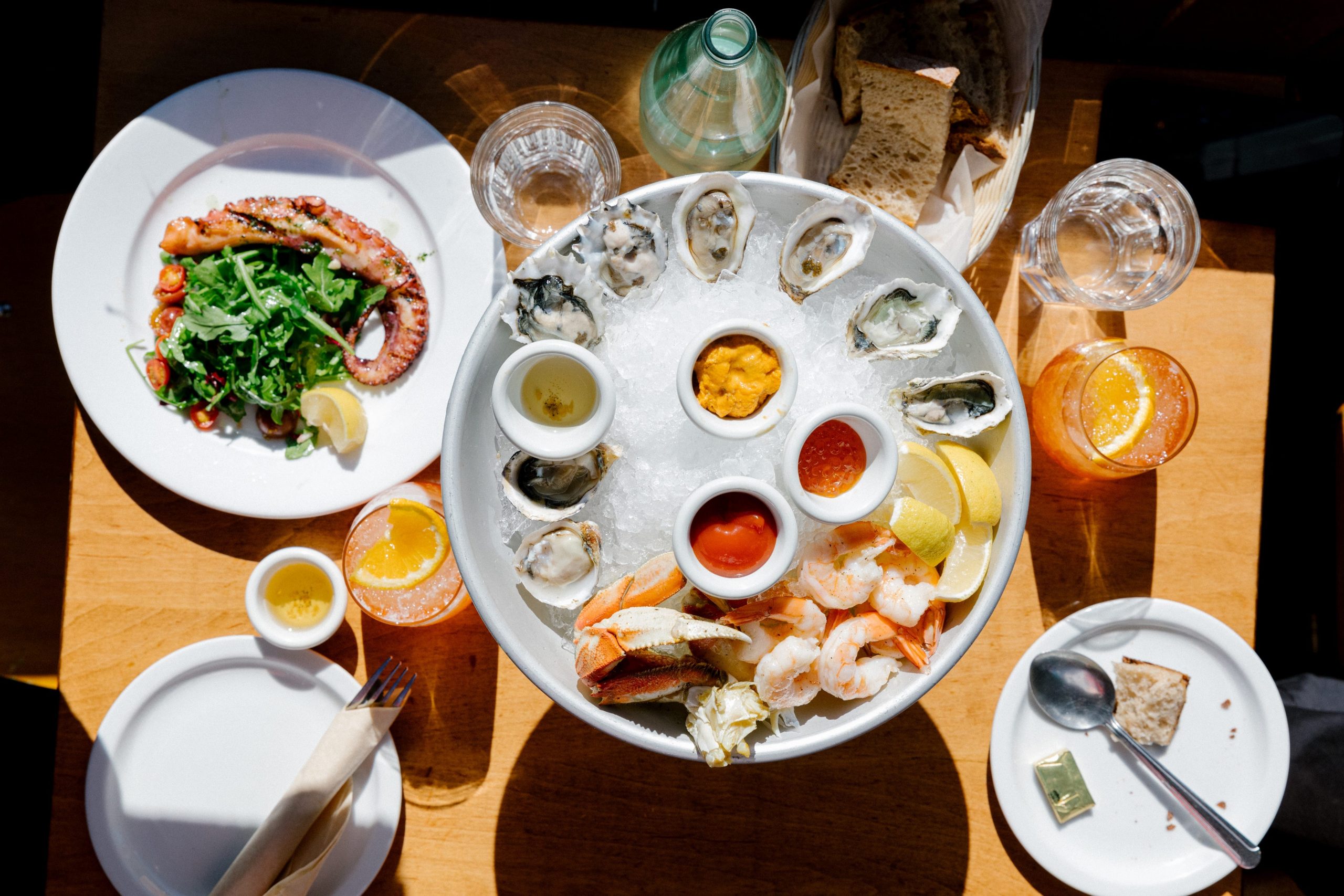 An overhead shot of a food spread, featuring shrimp, crab, and dipping sauces, at San Francisco's California Fish Market