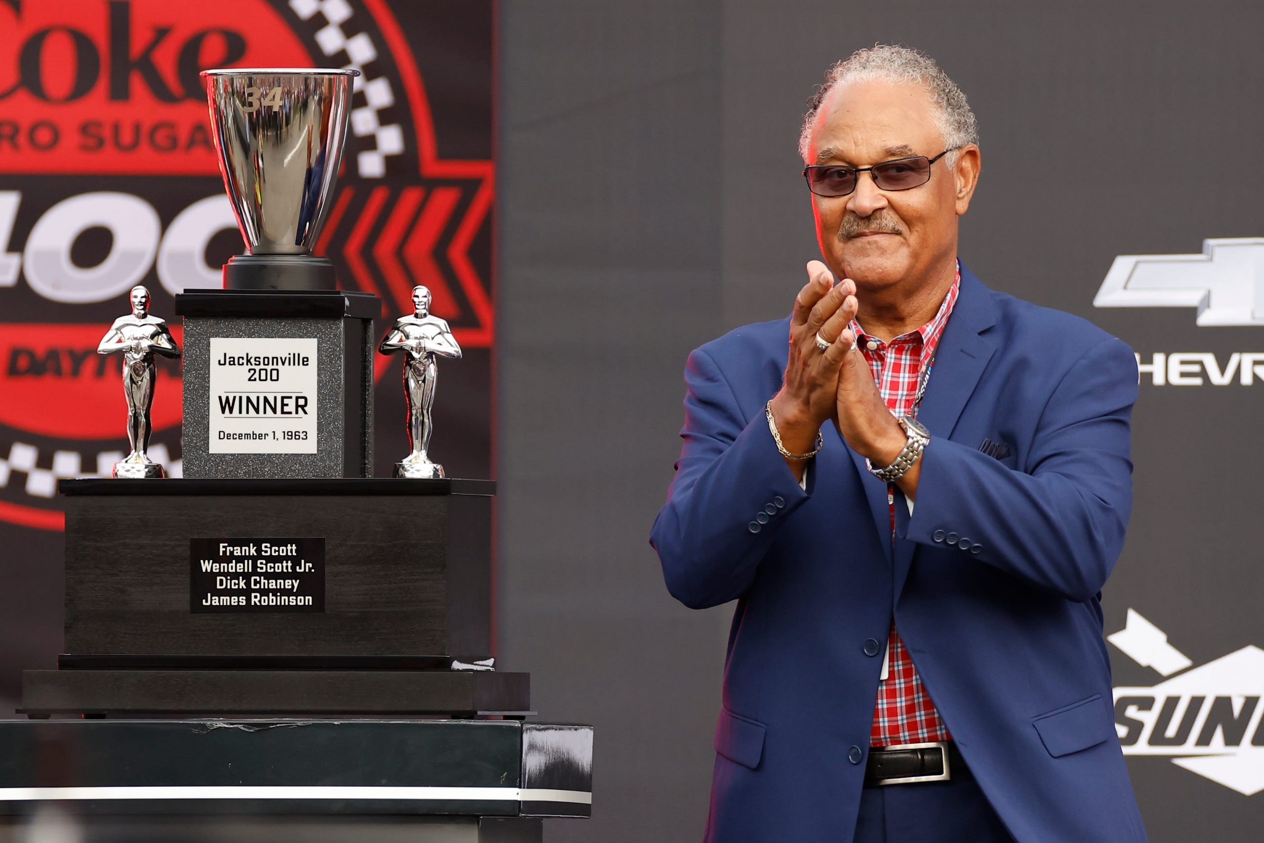 Frank Scott, Wendell Scott's son, posing with the honorary trophy from the Jacksonville 200.