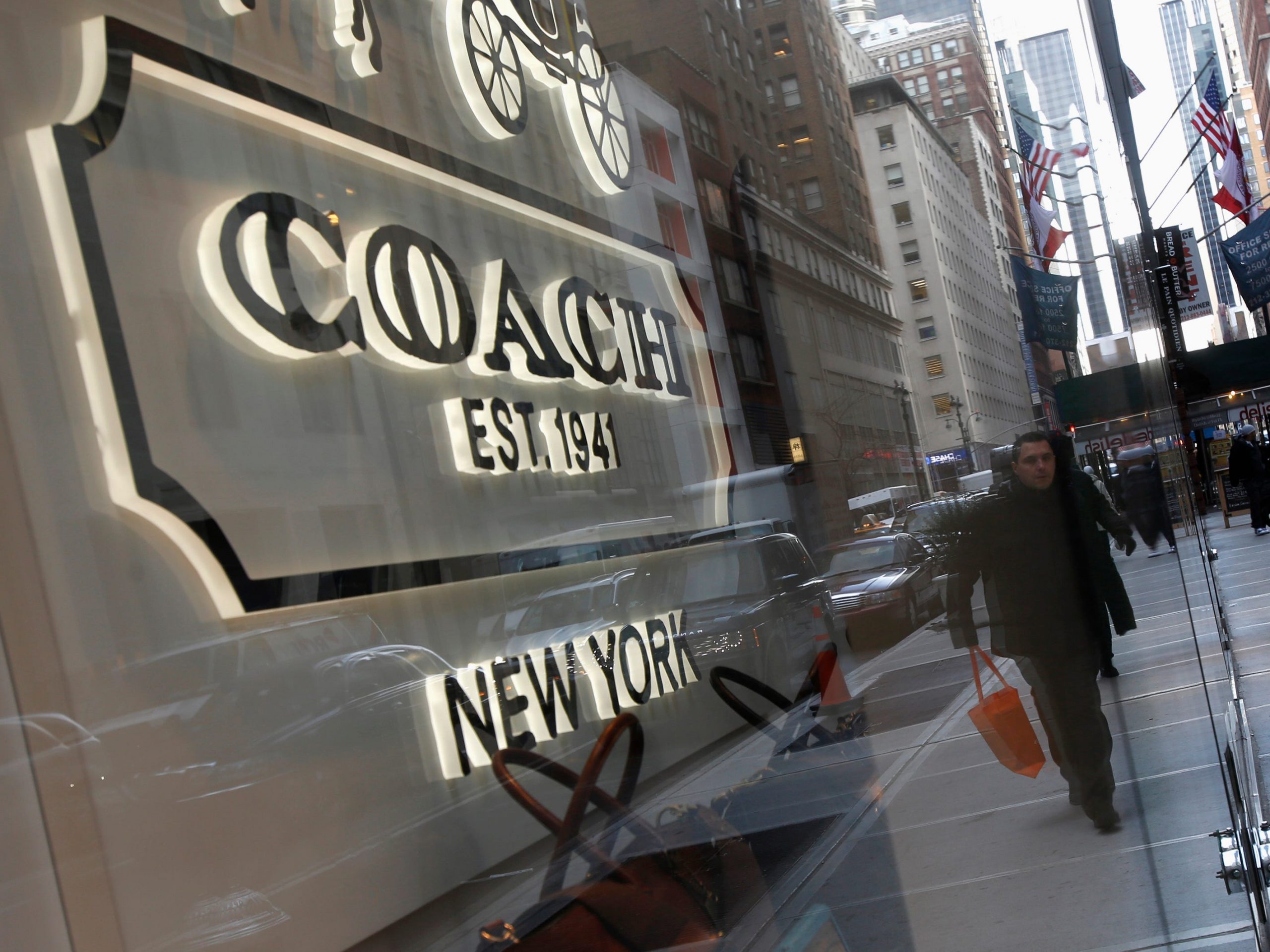 People walk past a Coach store on Madison Avenue in New York, January 23, 2013.