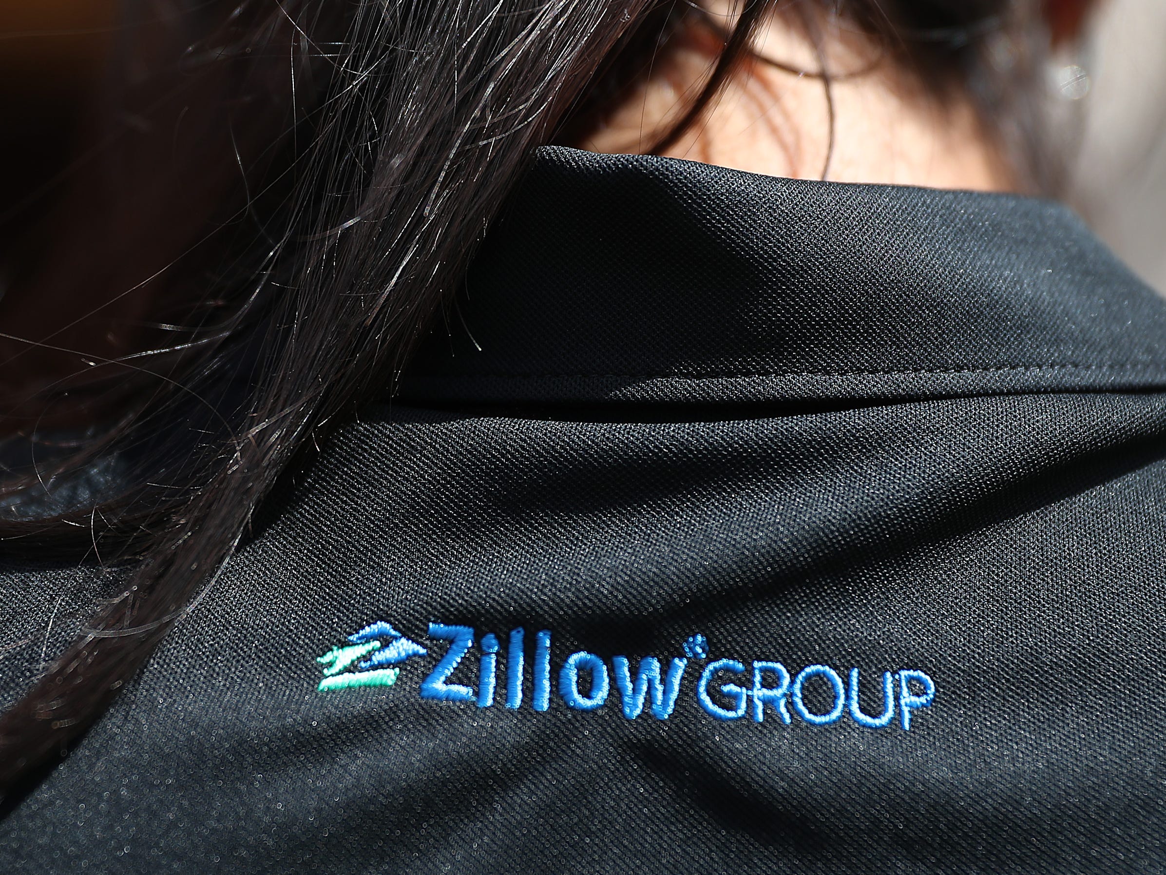 A Zillow employee's black polo shirt with "Zillow Group" embroidered on the back