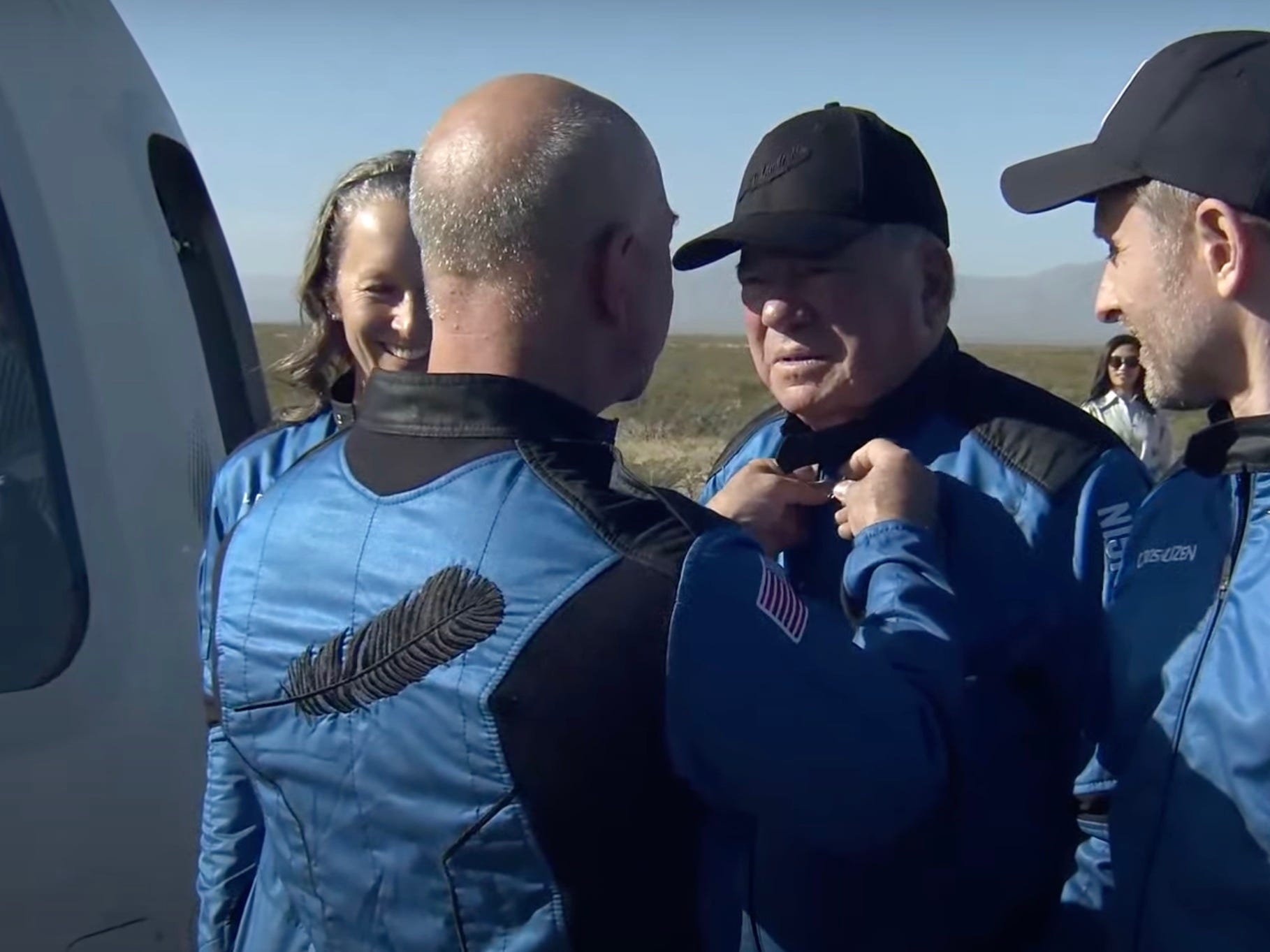 jeff bezos pins astronaut wings to william shatner space jumpsuit