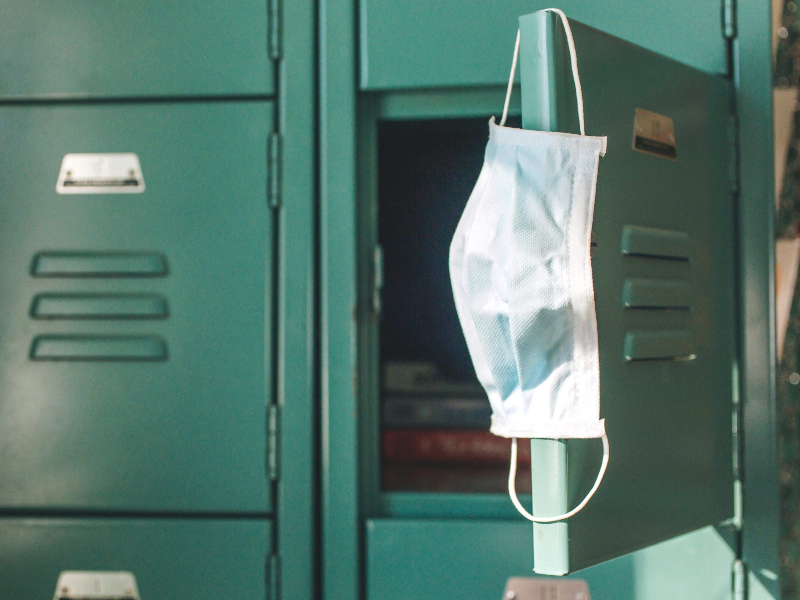 Surgical mask hanging inside school on locker.