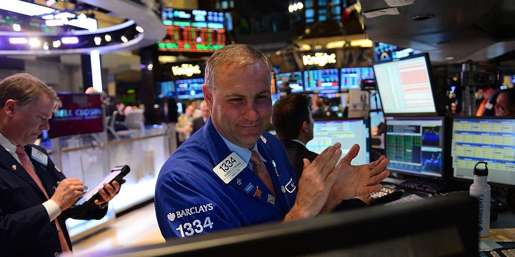 A stock trader claps at the end of trade at the New York Stock Exchange