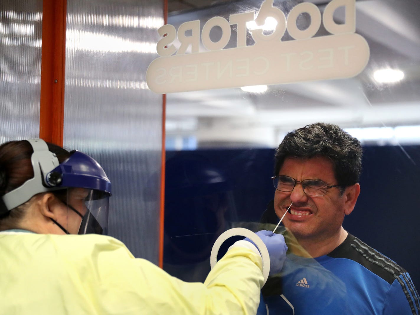 Luis Mostacero receives a Covid-19 test from testing technician Jamie Kunzer at Doctors