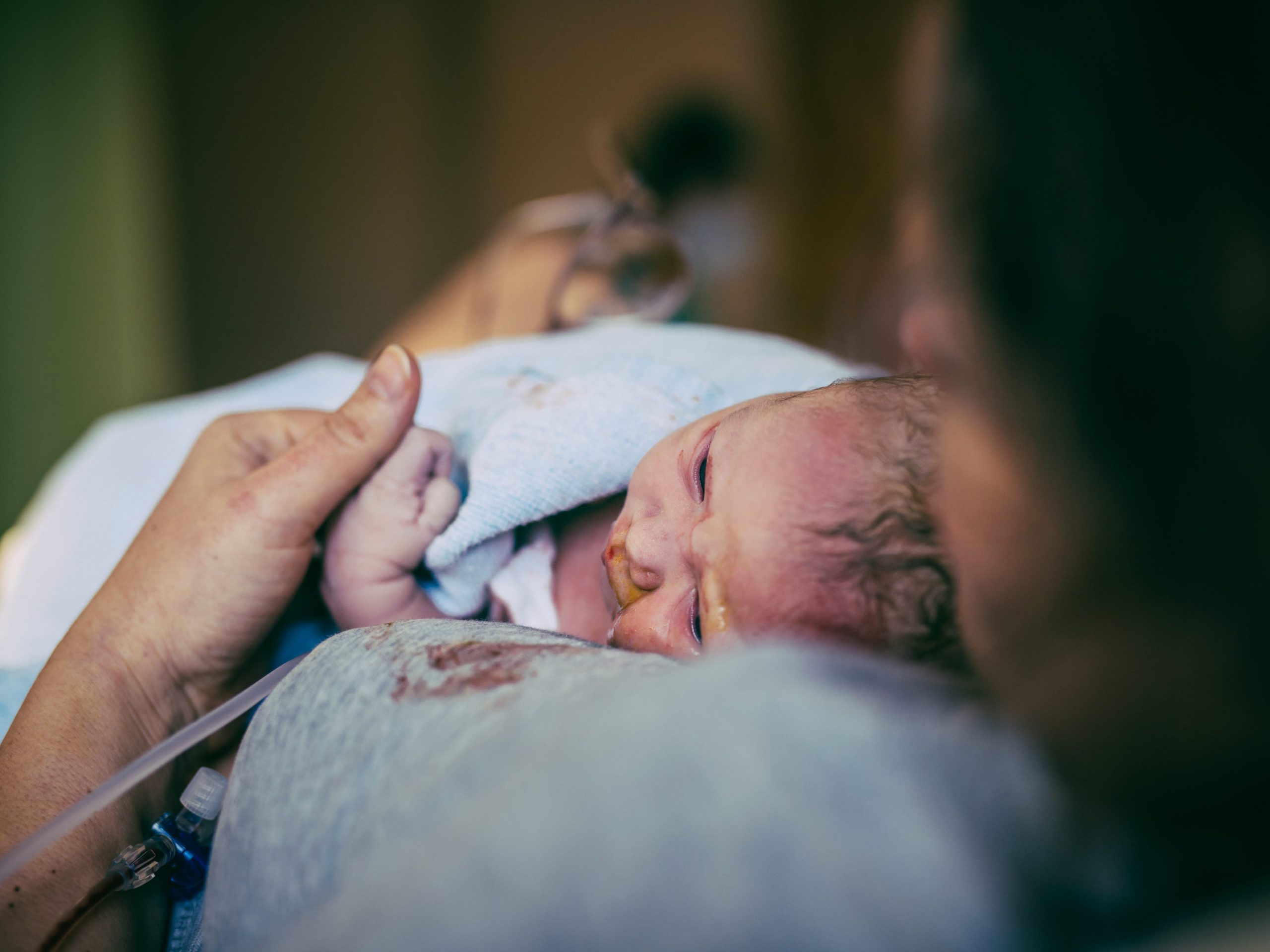 Woman holding her newborn after birth in hospital.