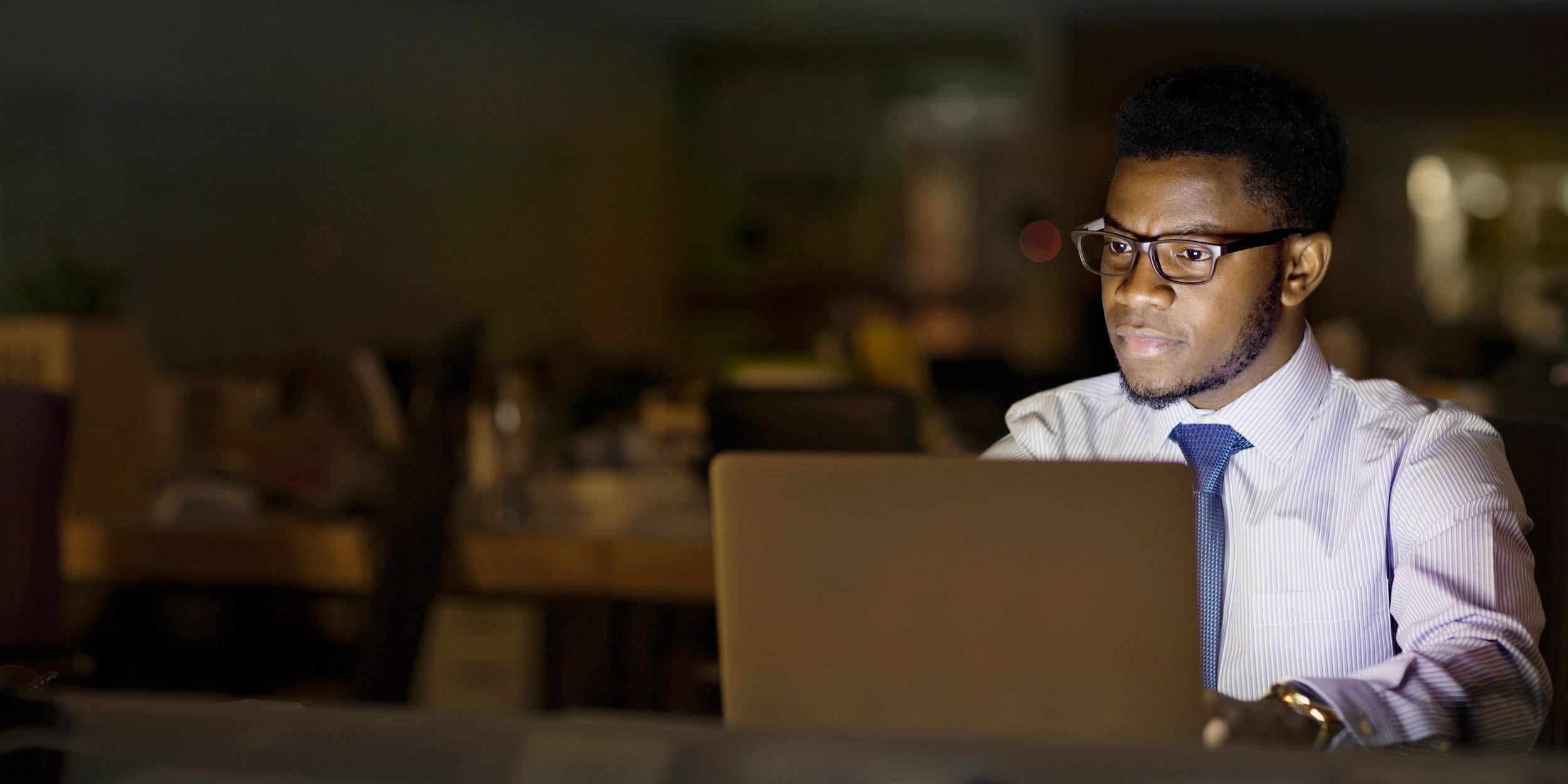 Business professional using laptop in office at night