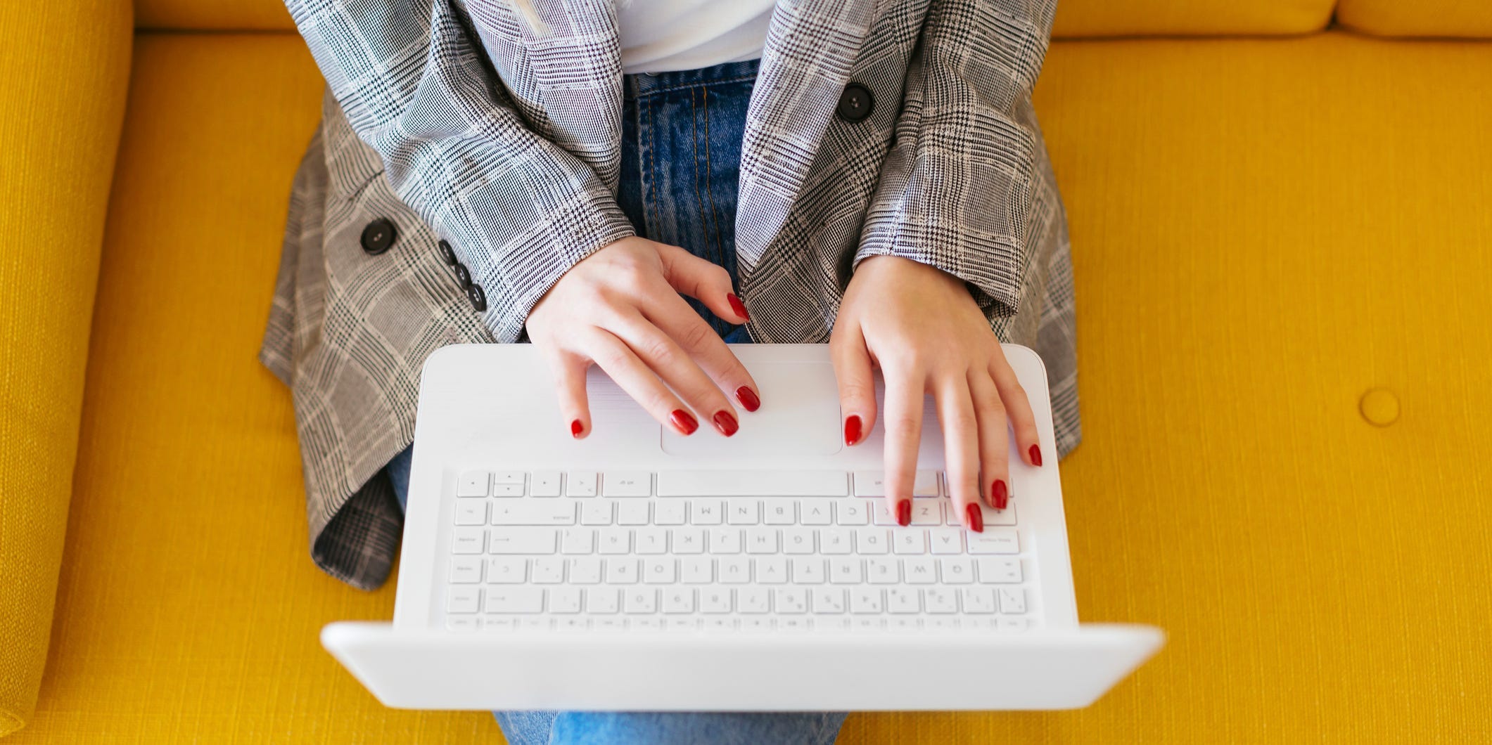 Woman sitting on couch working on laptop