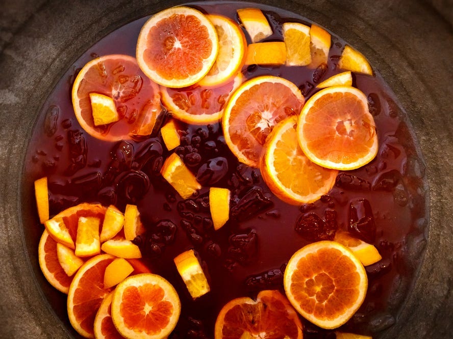 An overhead shot of a punchbowl with fruit in it.