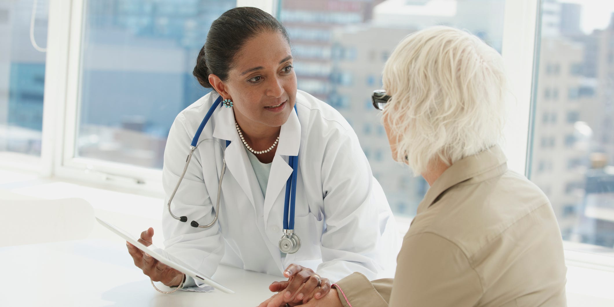 woman doctor talking to elderly person