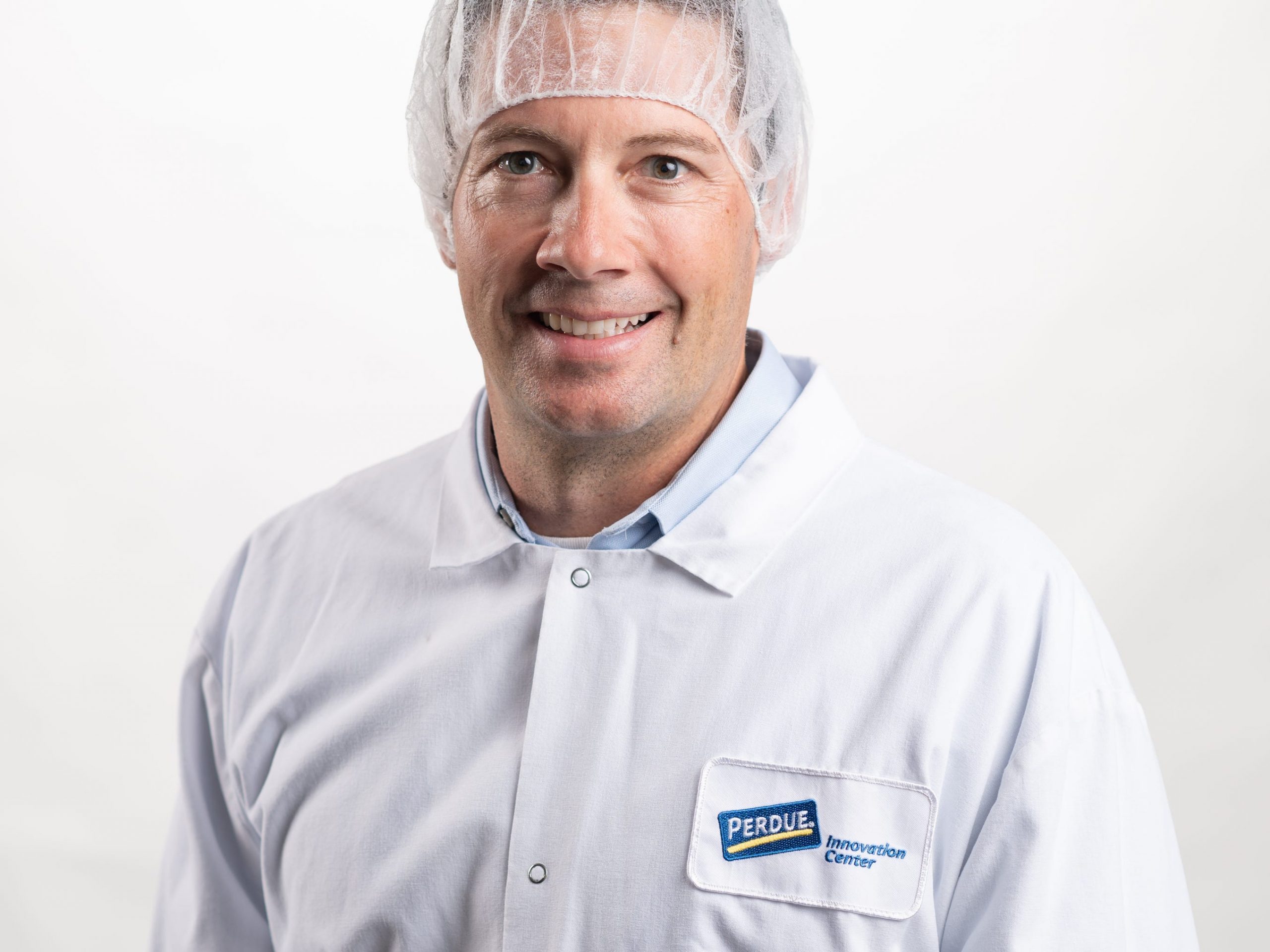 man in a white coat and hairnet