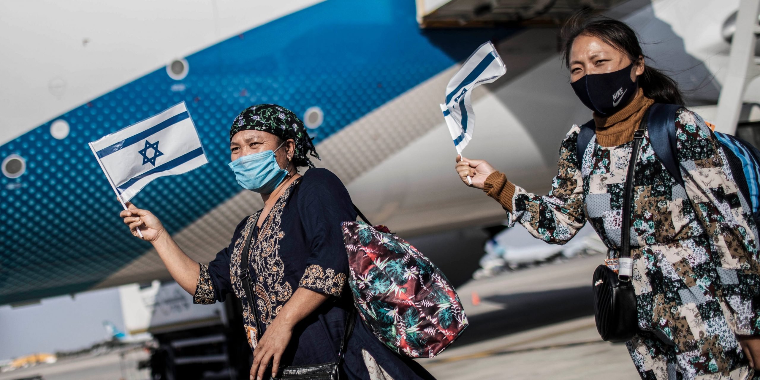 New Jewish emigrants from the Bnei Menashe (sons of Manasseh) community in India, hold Israeli flags as they cheer upon arrival at Ben Gurion Airport near Tel-aviv. 250 emigrants of Bnei Menashe community, claimed to be one of the Ten Lost Tribes of Israel that settled in India, have arrived today in Israel as part of an operation by the Ministry of Aliyah and Integration