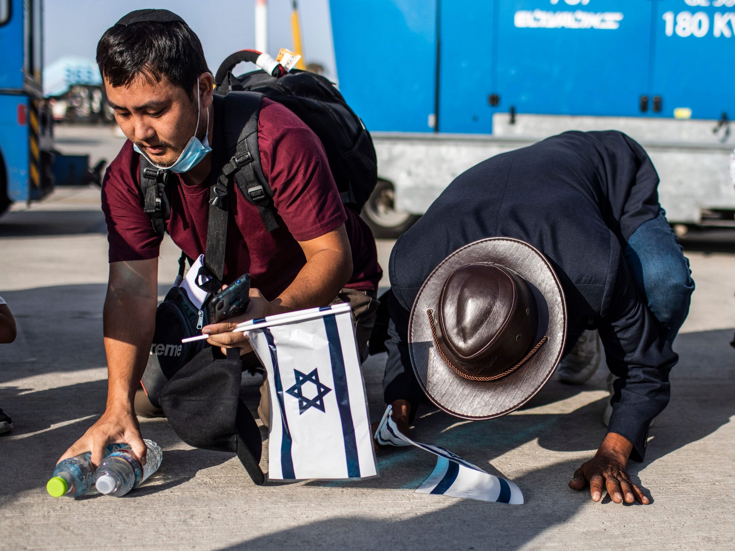 New Jewish emigrants from the Bnei Menashe (sons of Manasseh) community in India, kneel to the ground as they cheer after arriving at Ben Gurion Airport near Tel-aviv