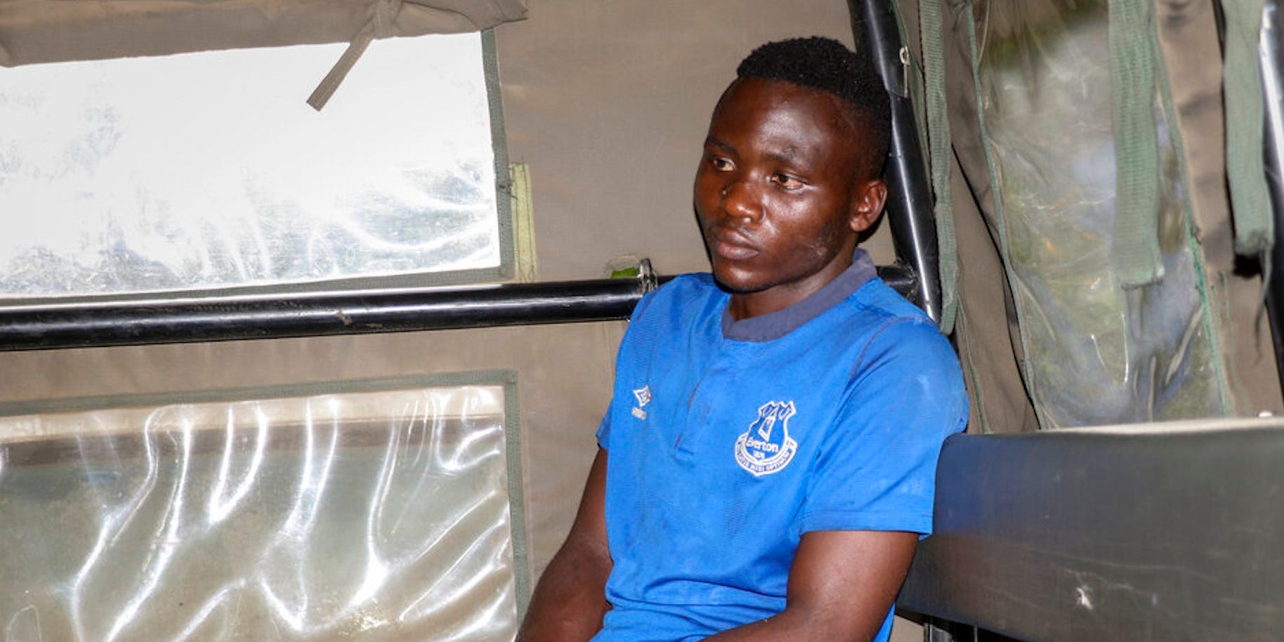 Masten Wanjala sits in the back of a police truck