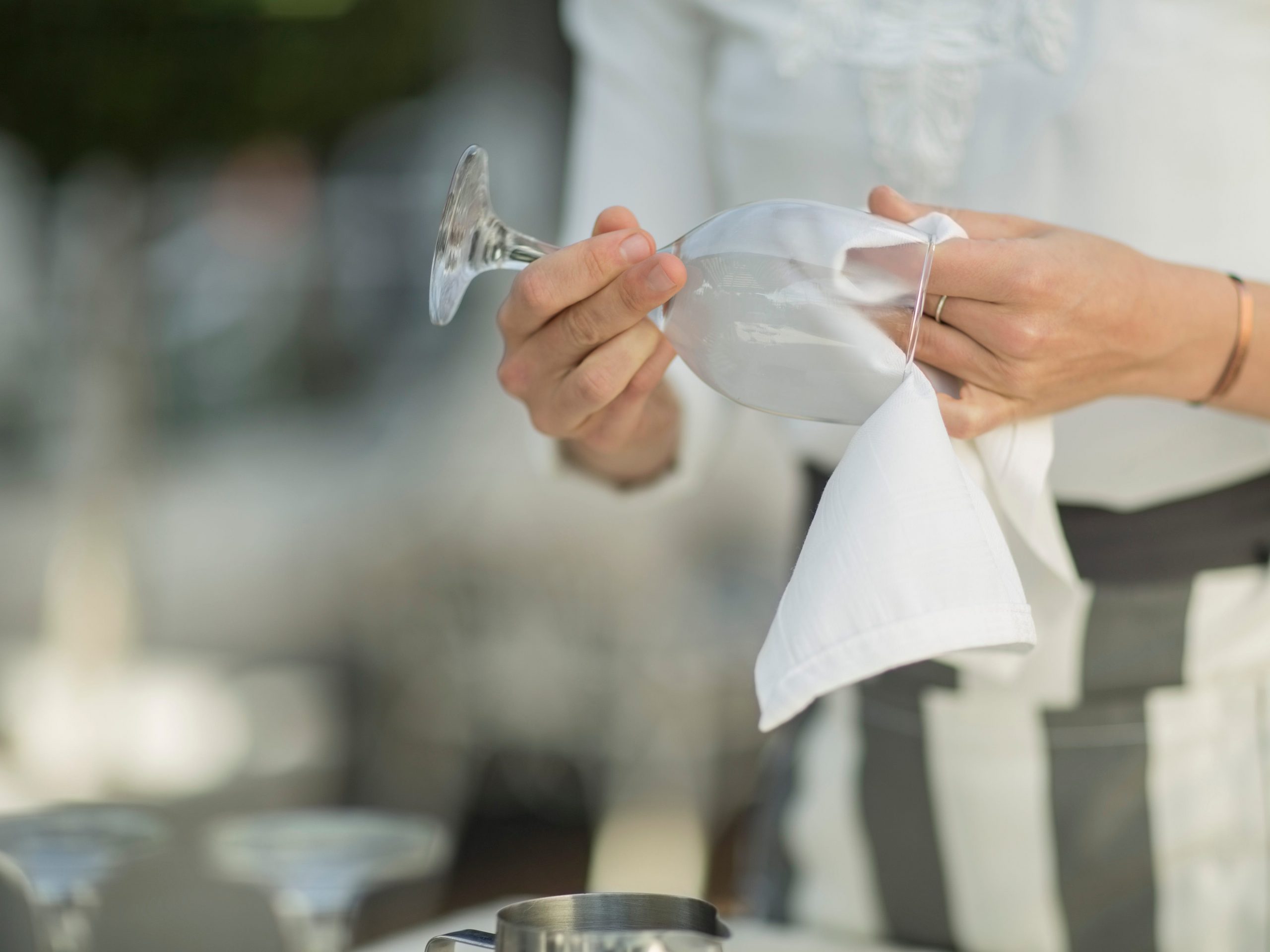 A waitress cleans a glass