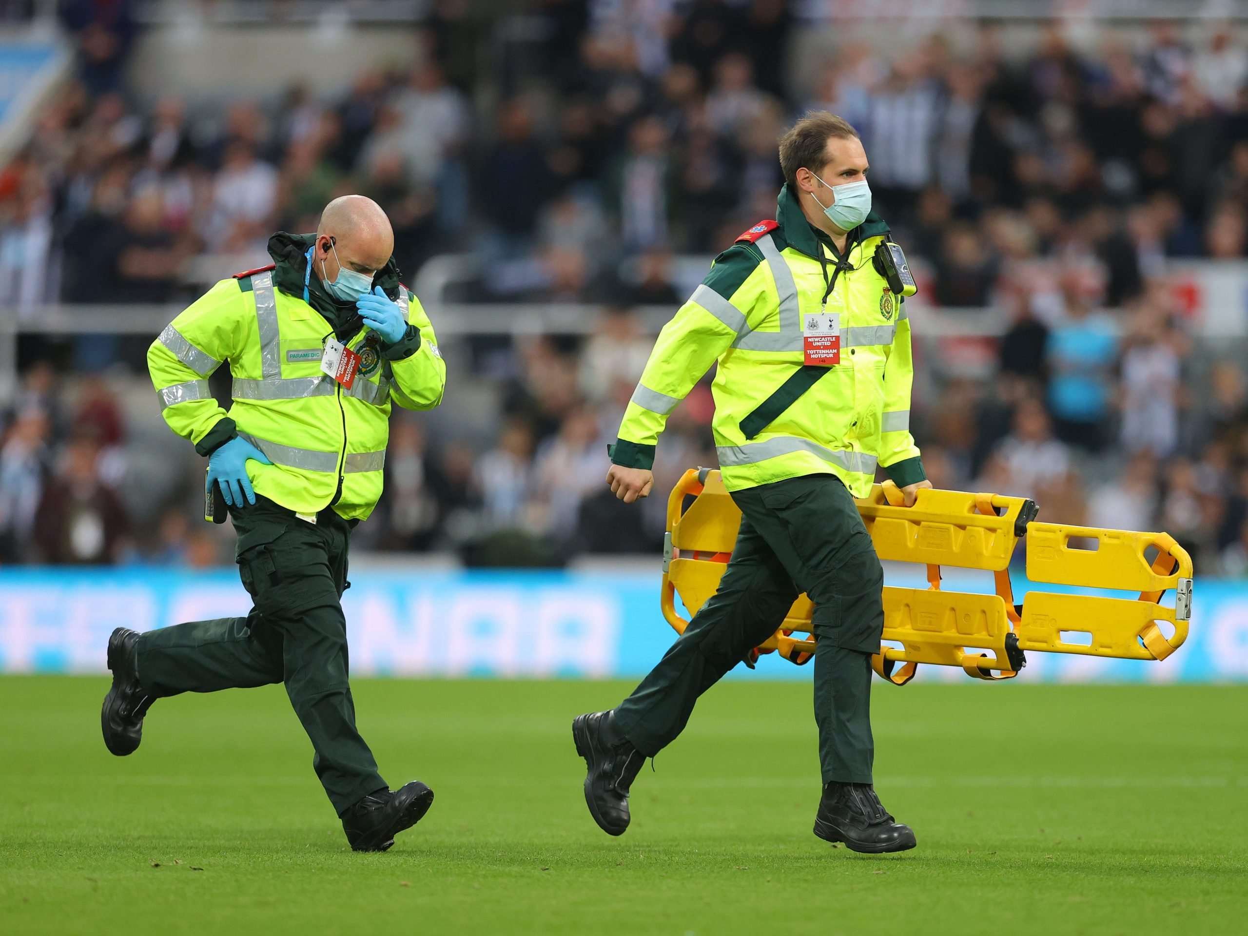 Medical staff running across the St James Park to help a collapsed fan