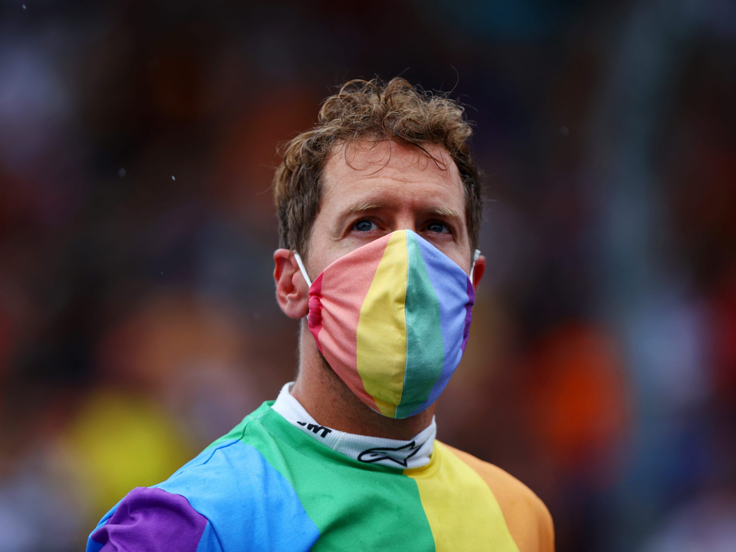 Sebastian Vettel wears a rainbow colored t-shirt and face mask