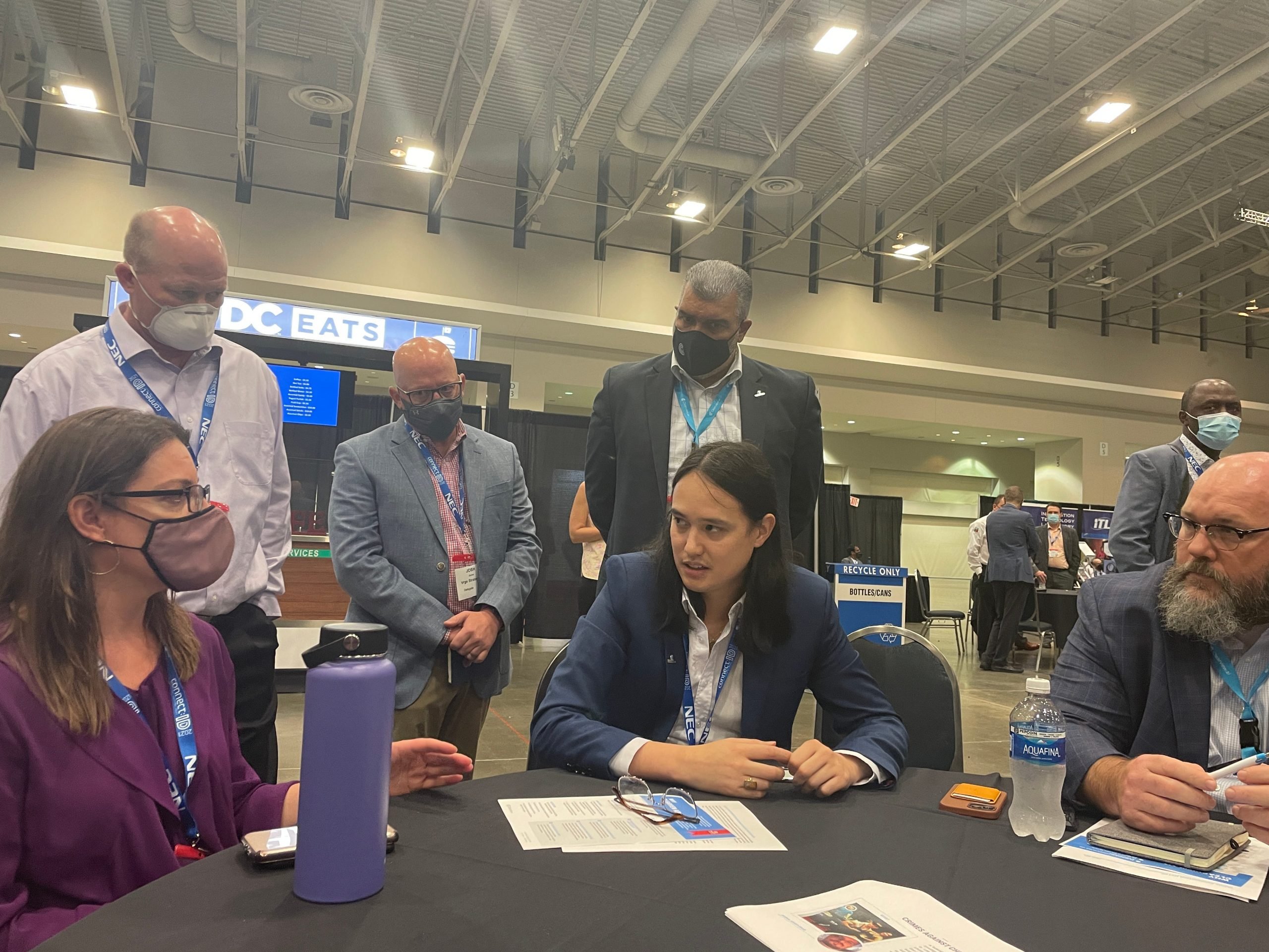 Clearview AI CEO Hoan Ton-That (center) is shown seated at a table during the Connect:ID surveillance technology conference in Washington DC in October 2021.