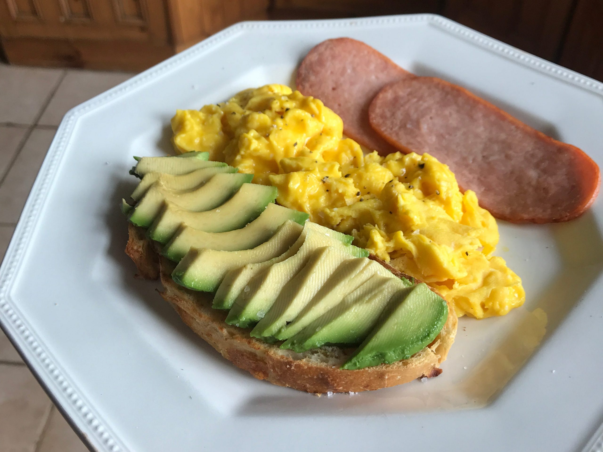 Avocado on toast, scrambled eggs, and turkey bacon.