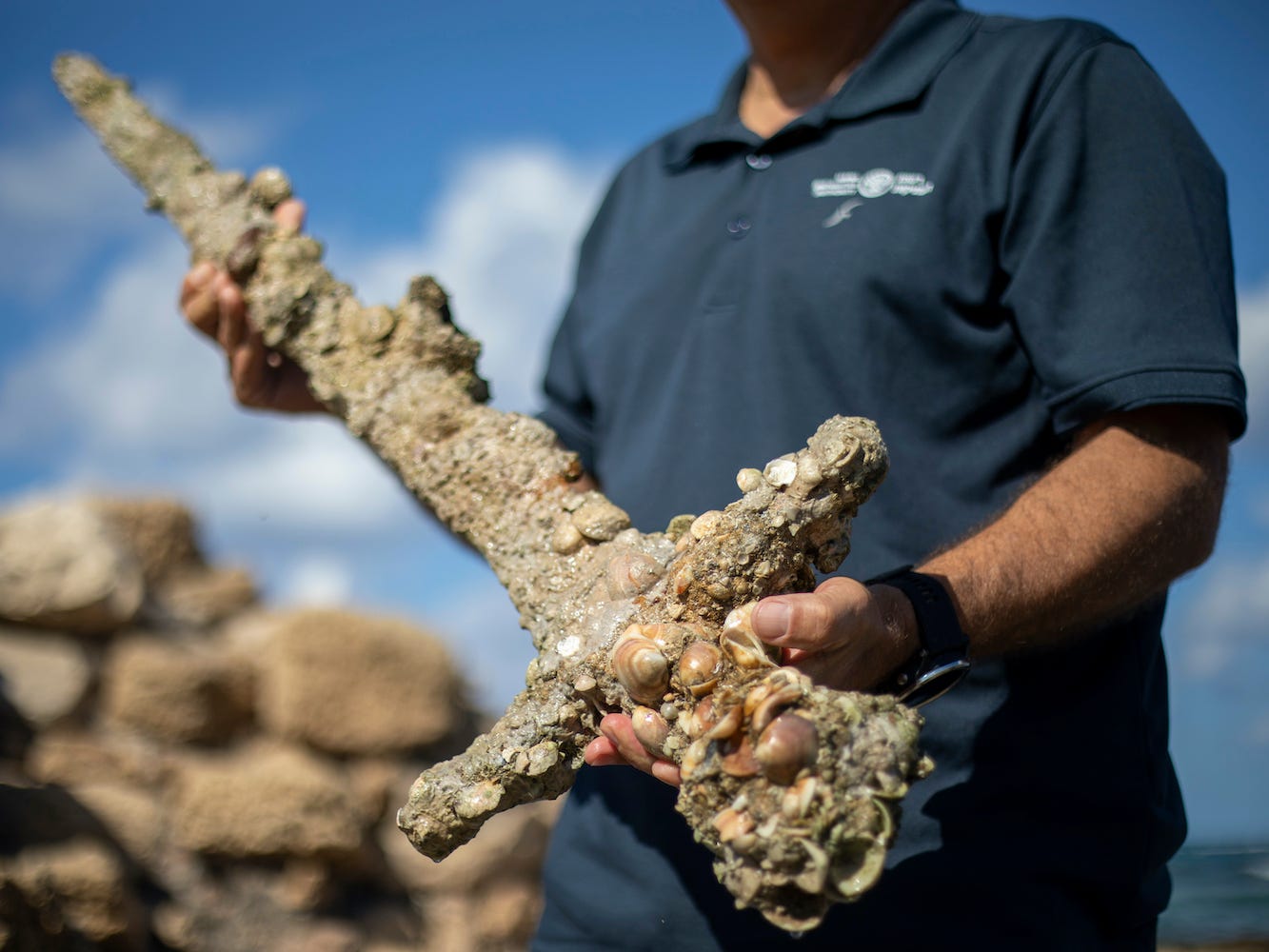 Jacob Sharvit, director of the Marine Archaeology Unit of the Israel Antiquities Authority holds a sword that experts say dates back to the Crusaders.