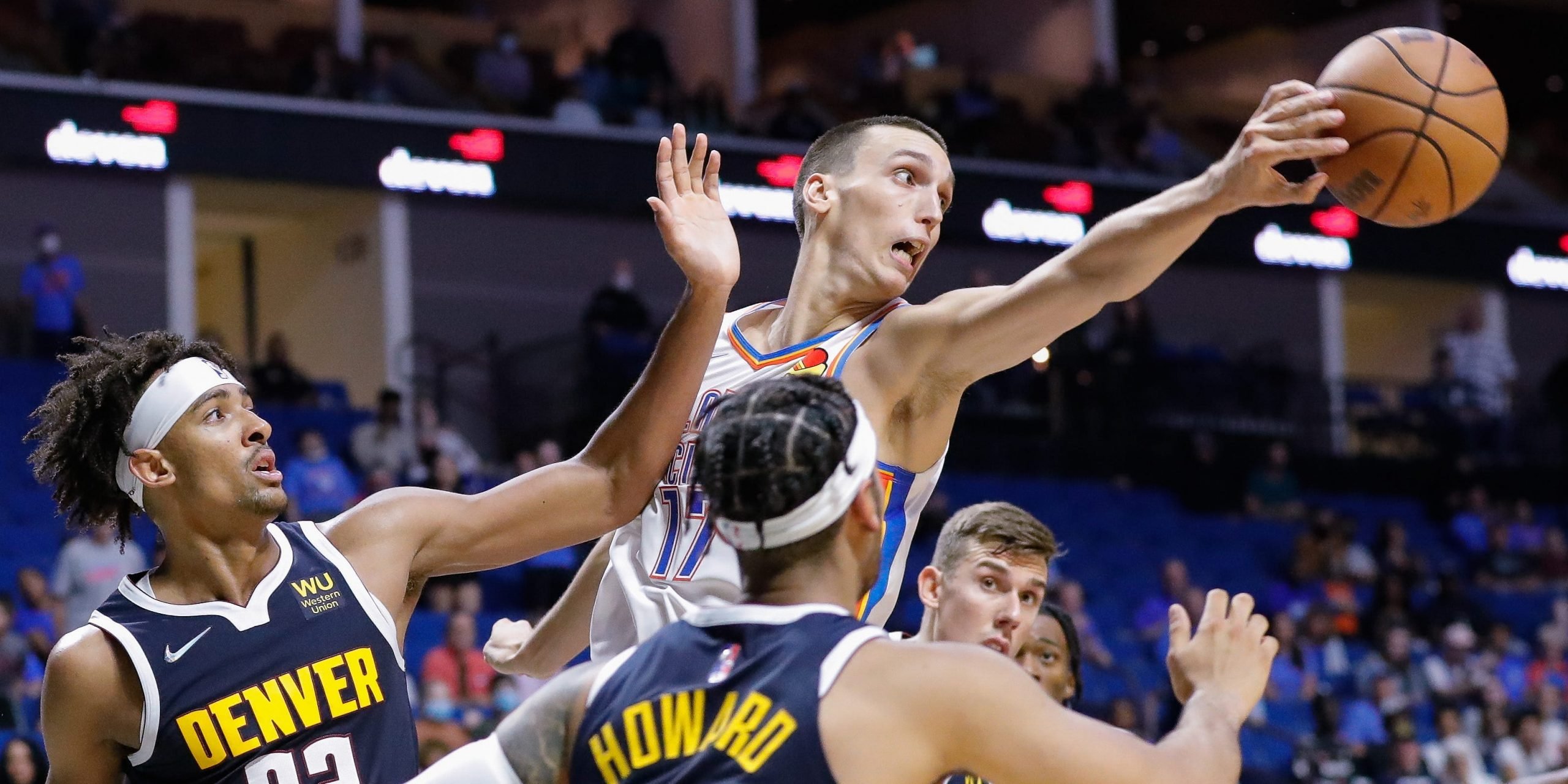 Oklahoma City Thunder forward Aleksej Pokusevski (17) passes a rebound backwards to a teammate during the second half of a preseason game against the Denver Nuggets at BOK Center.