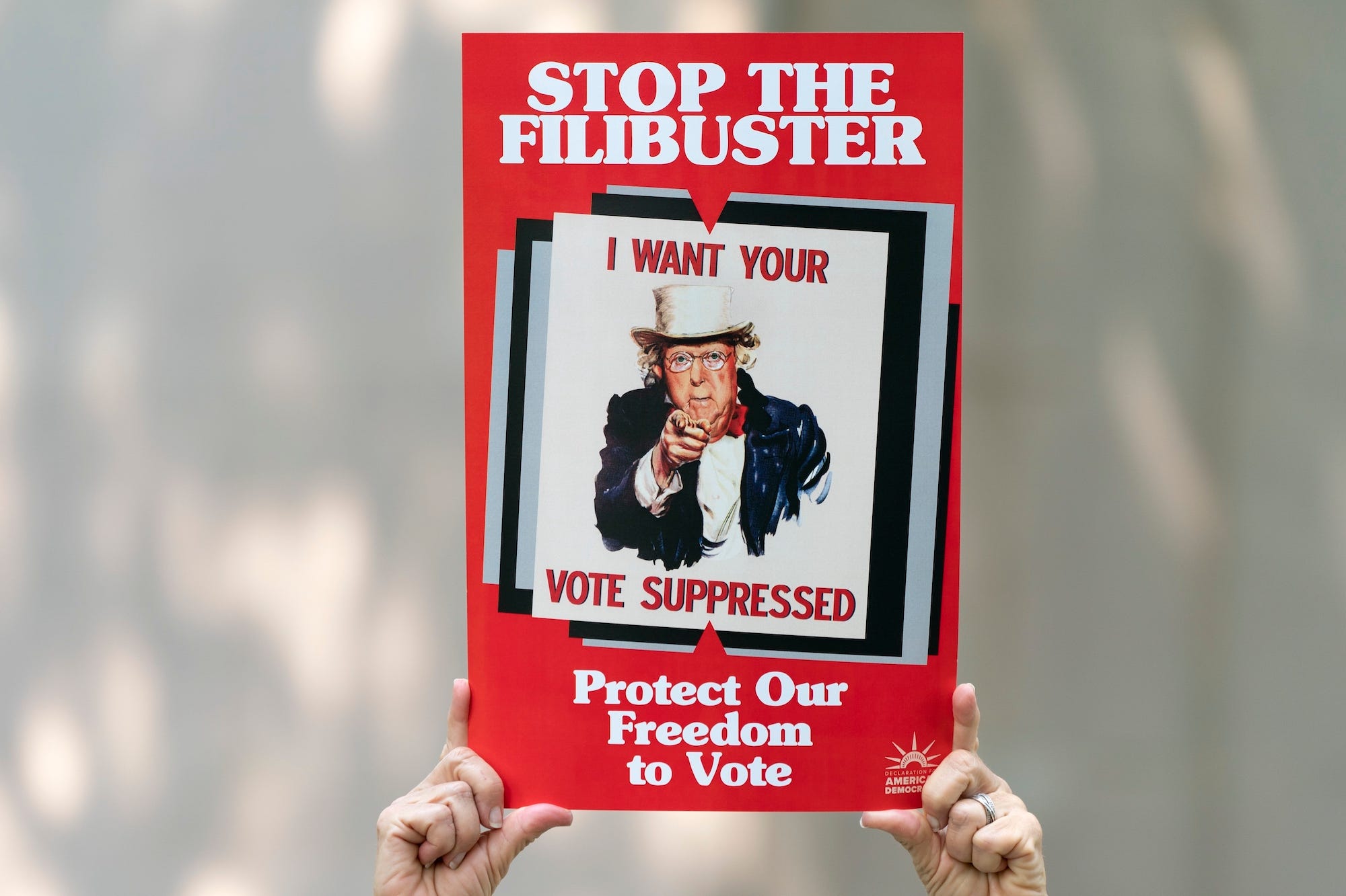 Virginia Shadron, of Atlanta, holds an anti-filibuster sign with the face of Senate Minority Leader Mitch McConnell of R-Ky., on it, during a rally in support of voting rights, Tuesday, Sept. 14, 2021, on Capitol Hill in Washington.