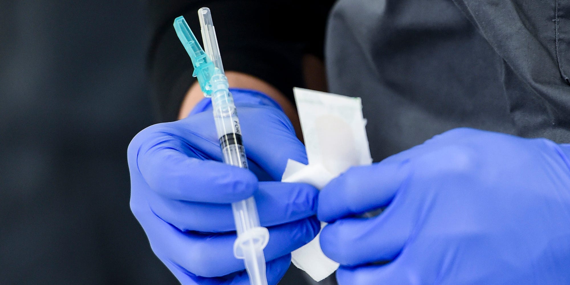 A healthcare worker holds a syringe of COVID-19 vaccine.