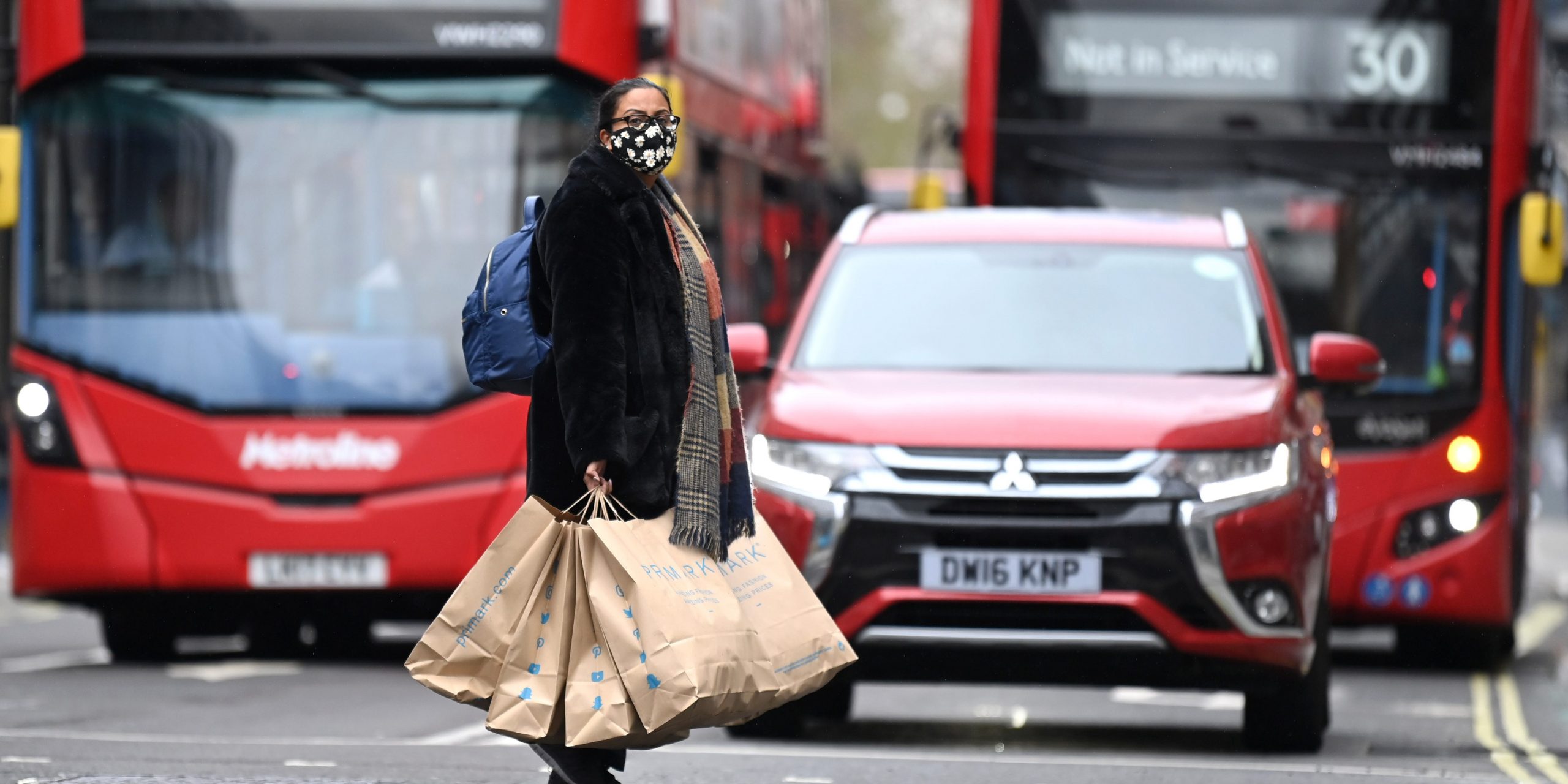 UK woman shopping shops red bus economy reopens London