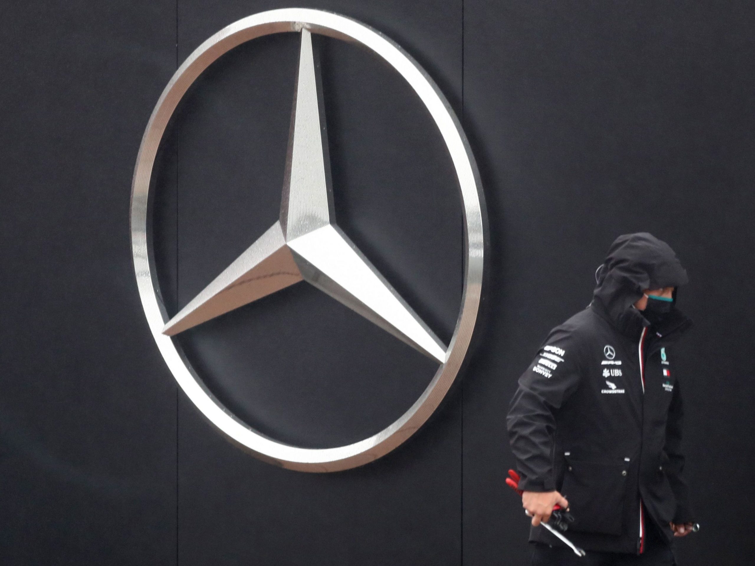 A team member walks past the Mercedes logo.