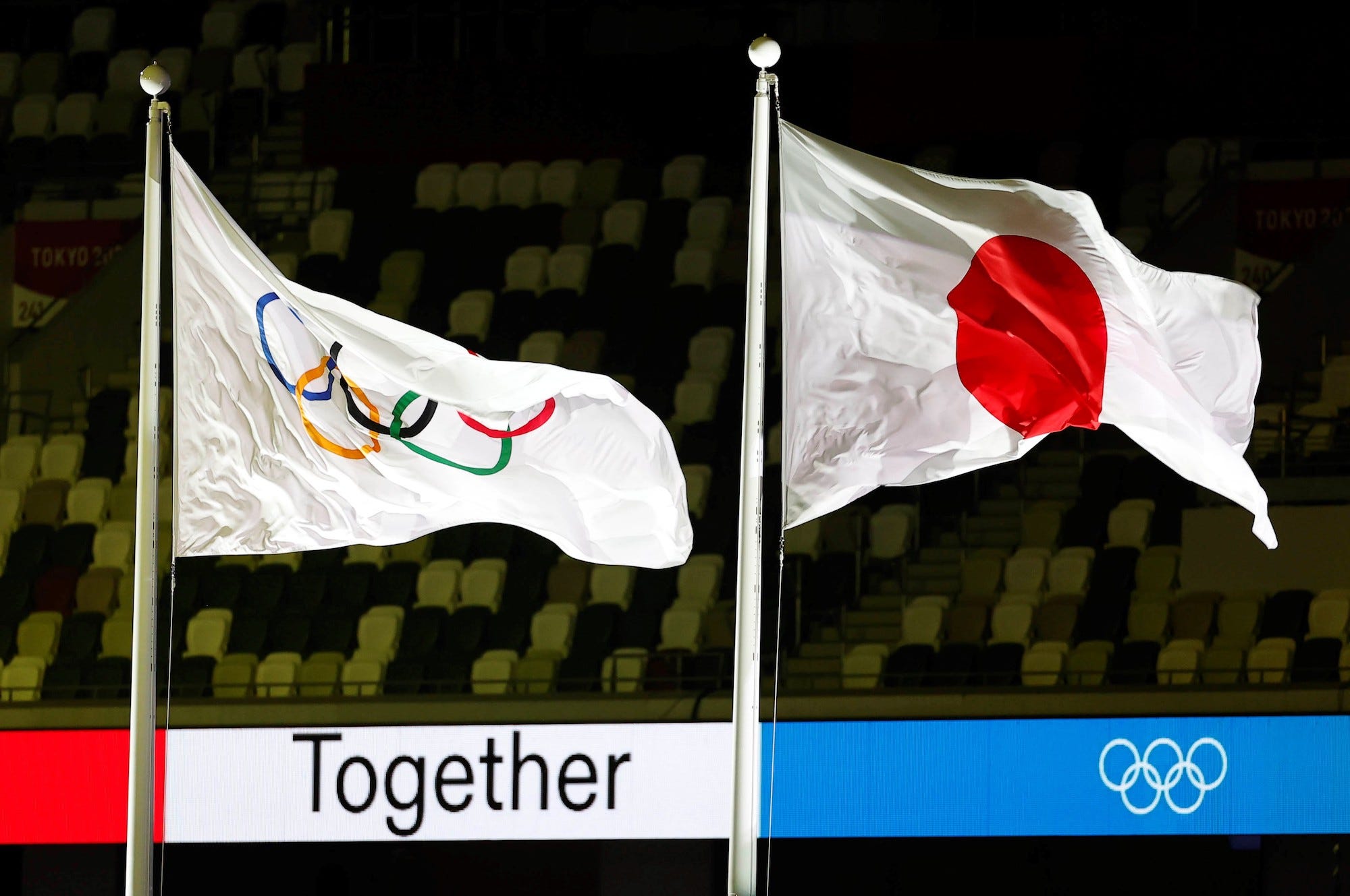 The Olympic flag and Japanese national flag are raised during the closing ceremony of Tokyo 2020 Olympic Games