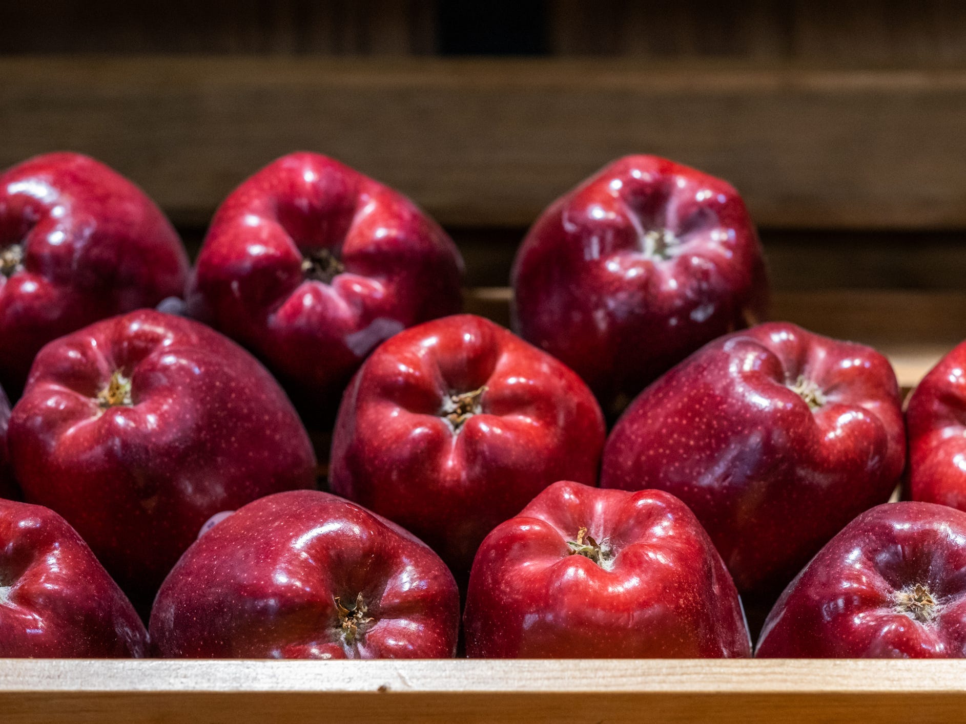 Some Red Delicious apples in a crate.