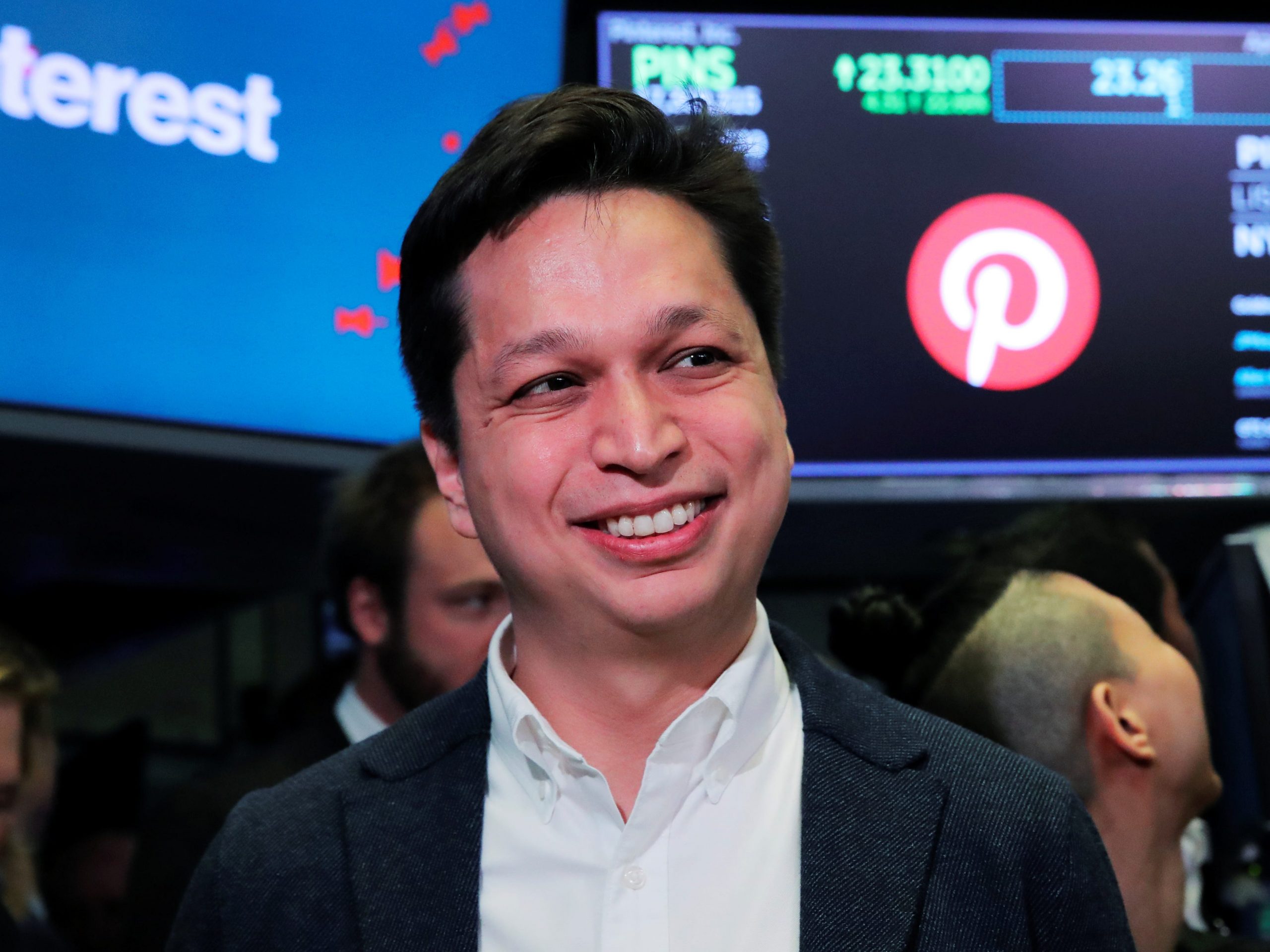 A headshot of Pinterest CEO Ben Silbermann on the stock exchange floor in front of a sign with the pinterest logo