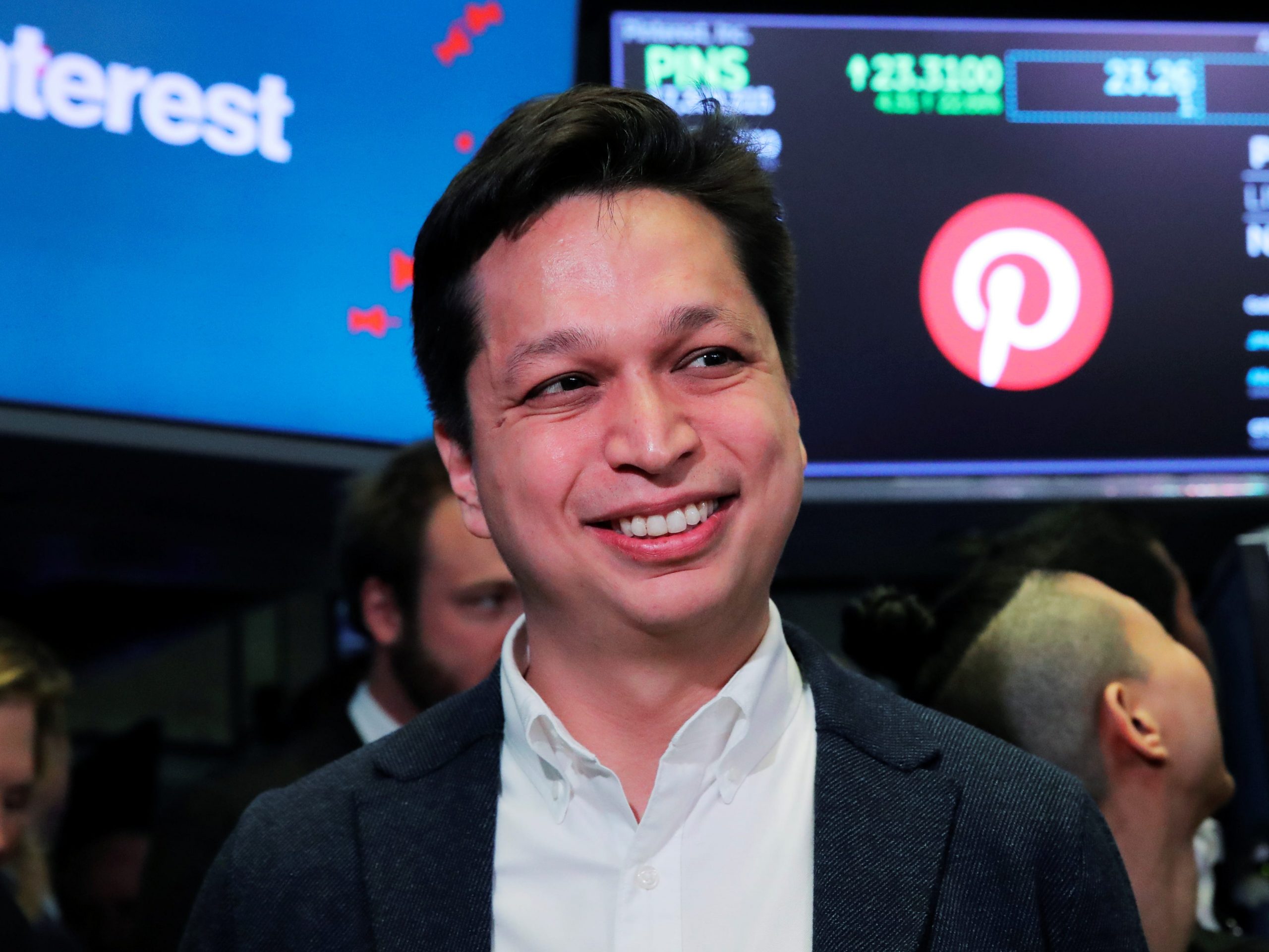 A headshot of Pinterest CEO Ben Silbermann on the stock exchange floor in front of a sign with the pinterest logo