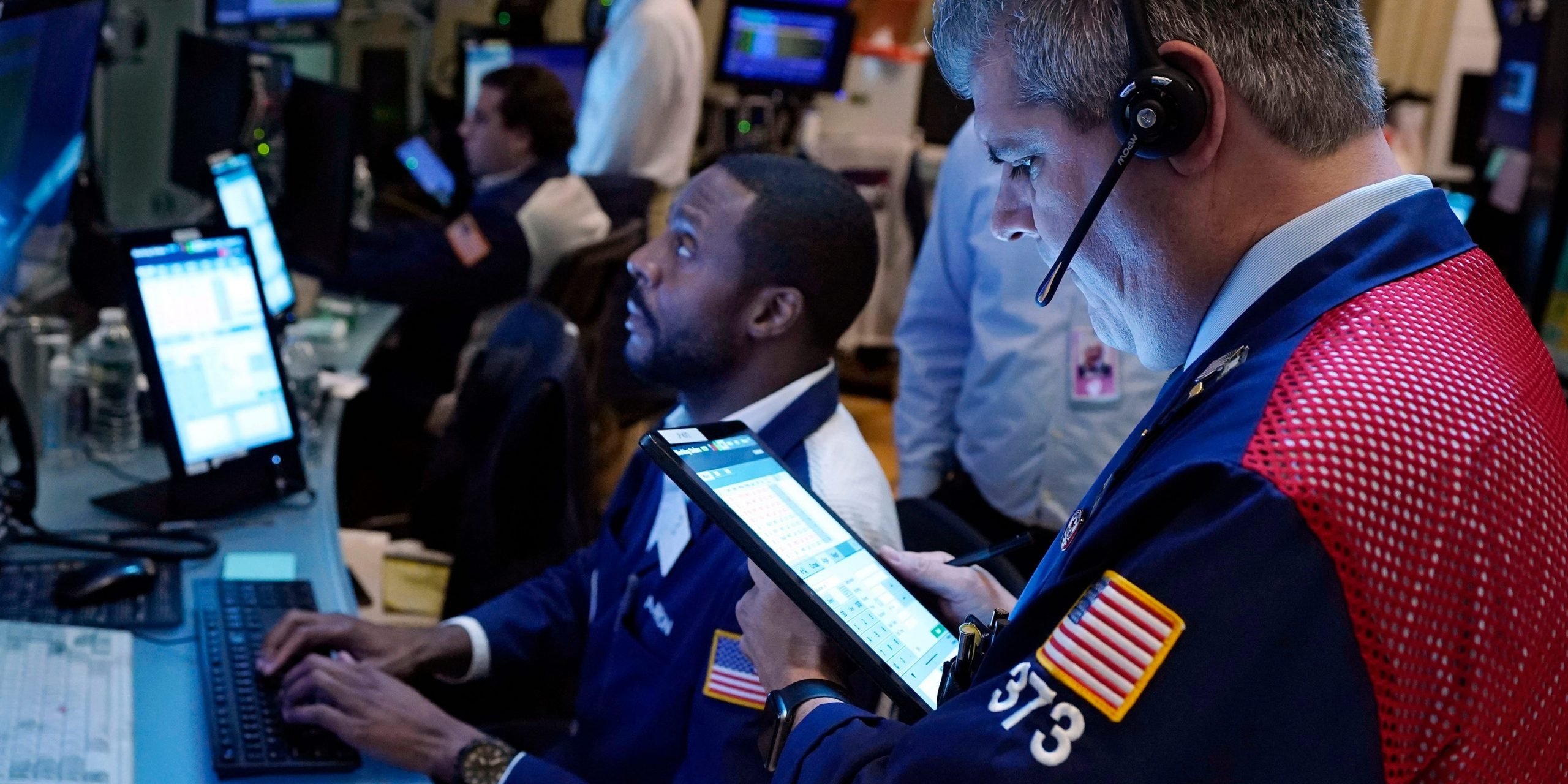 Two traders work on the floor of the New York Stock Exchange