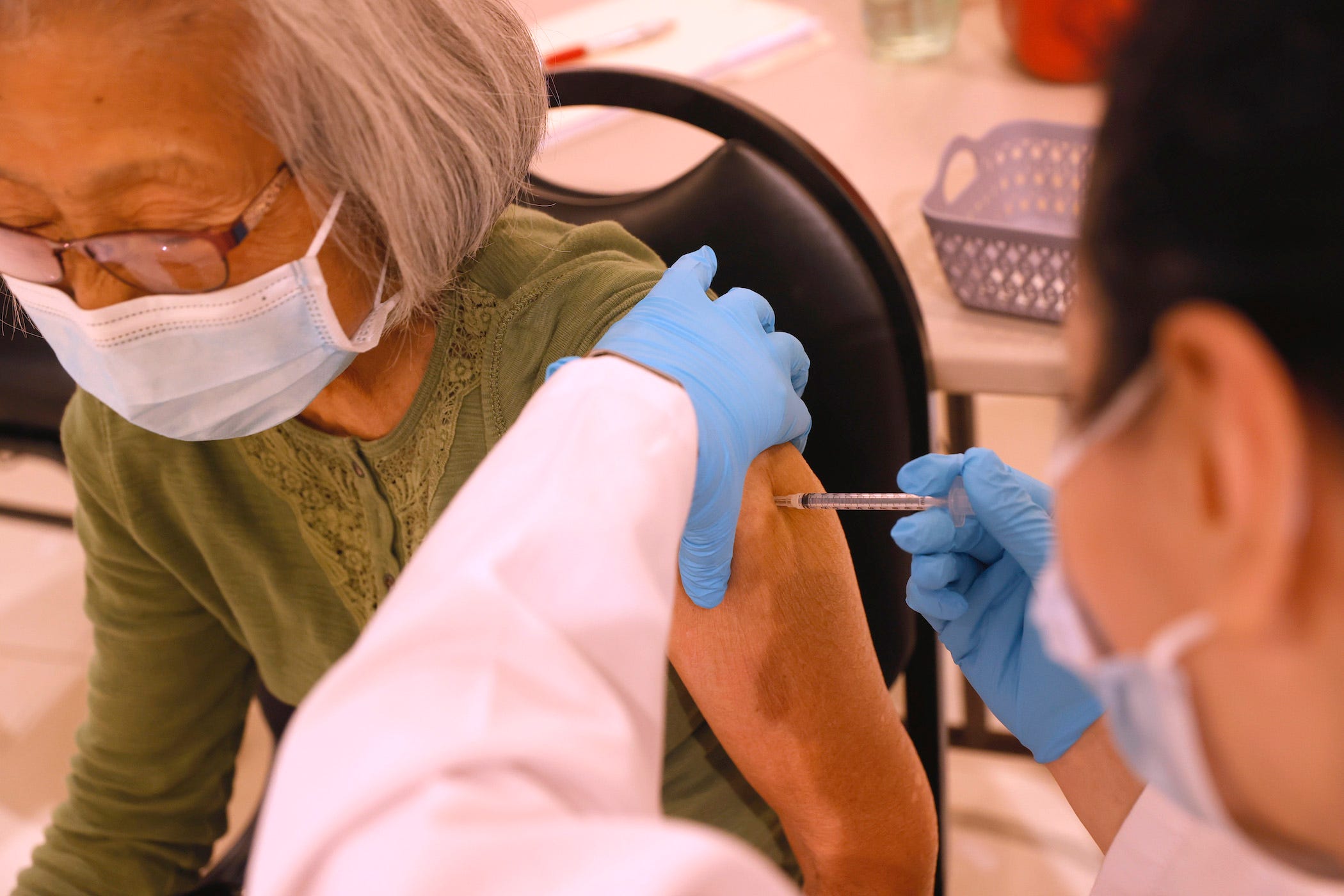 Safeway pharmacist Shahrzad Khoobyari (R) administers a Pfizer COVID-19 booster vaccination into the arm of Chen Knifsend at a booster shot clinic on October 1, 2021 in San Rafael, California.