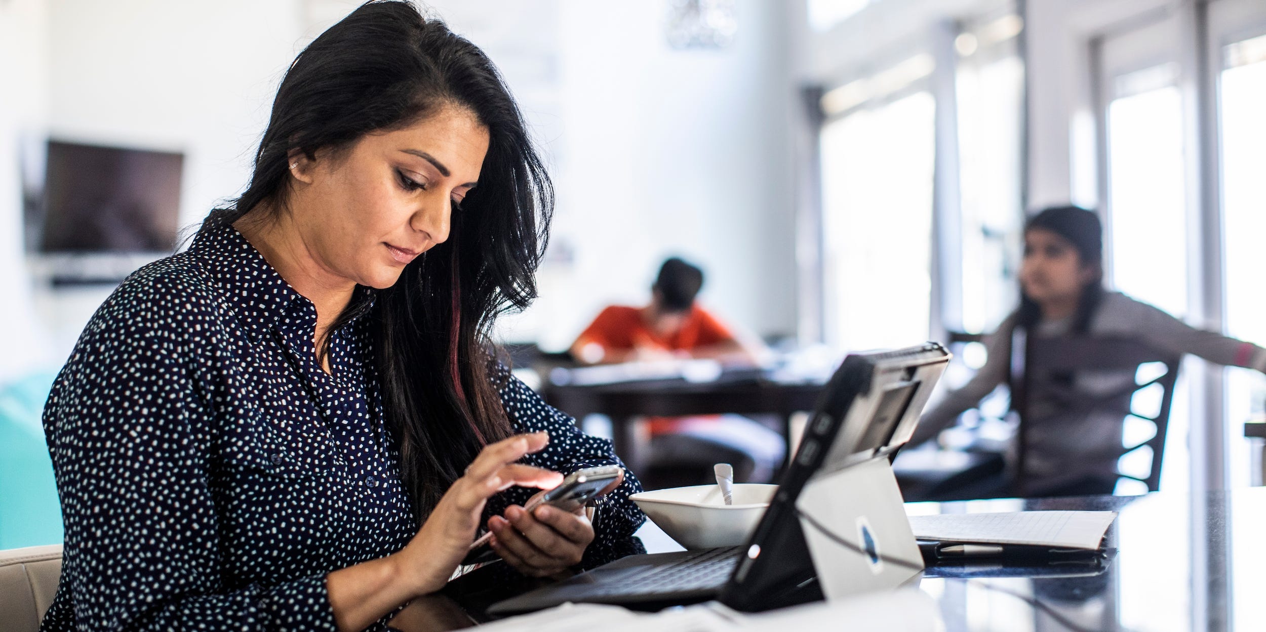 mother working from home on smartphone and tablet