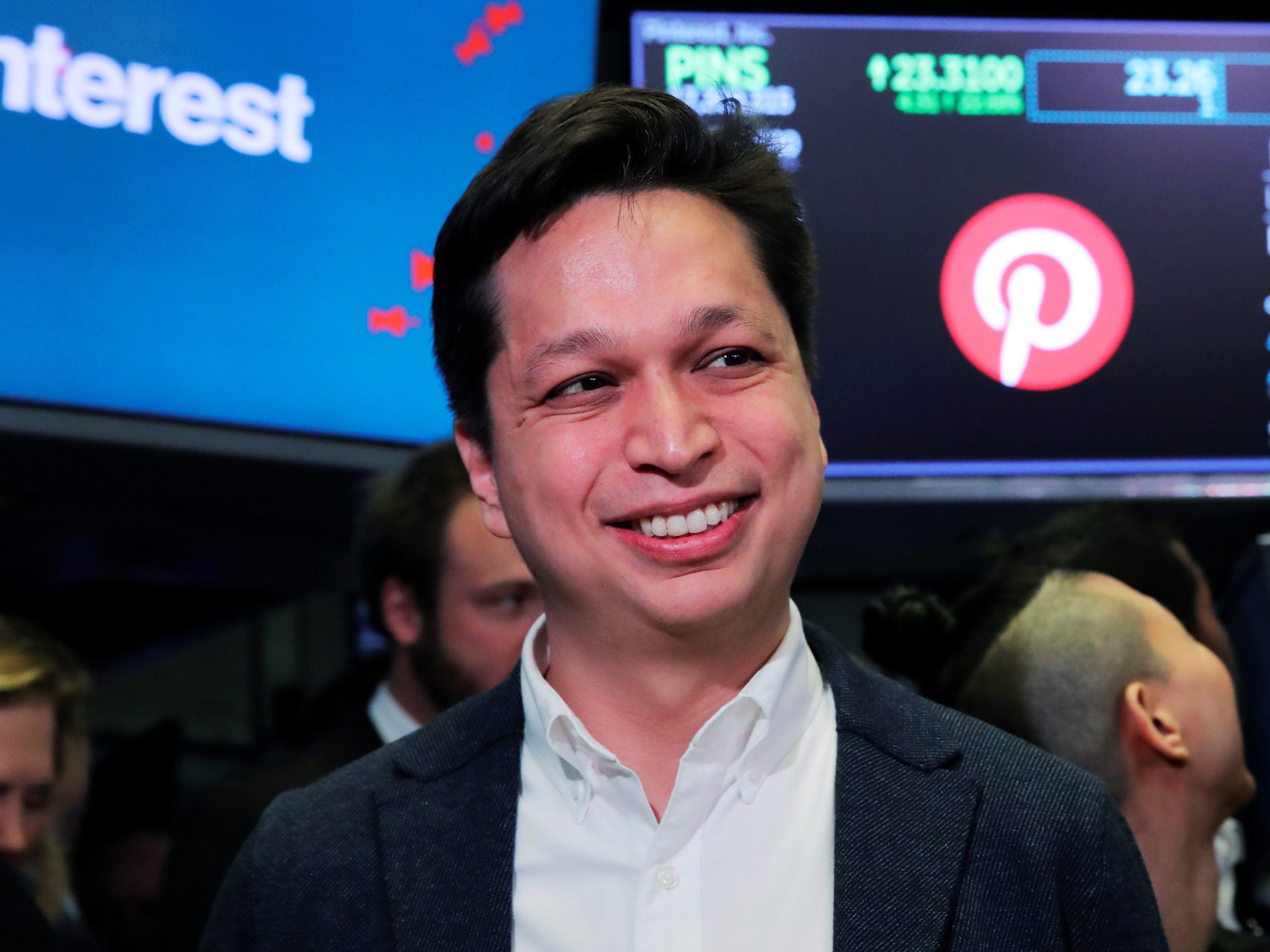 A headshot of Pinterest CEO Ben Silbermann on the stock exchange floor in front of a sign with the pinterest logo