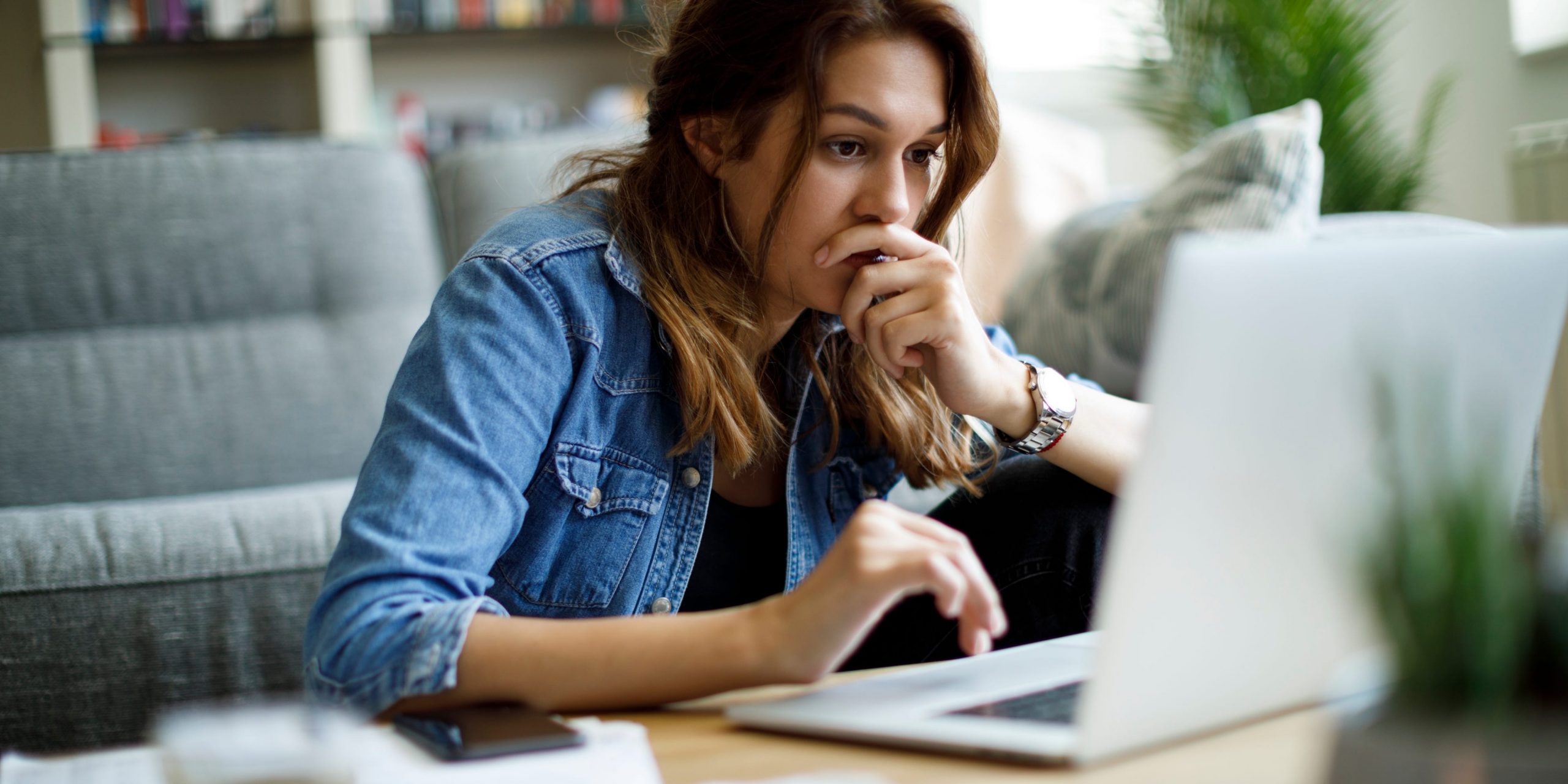 Worried young woman working at home upset work computer laptop