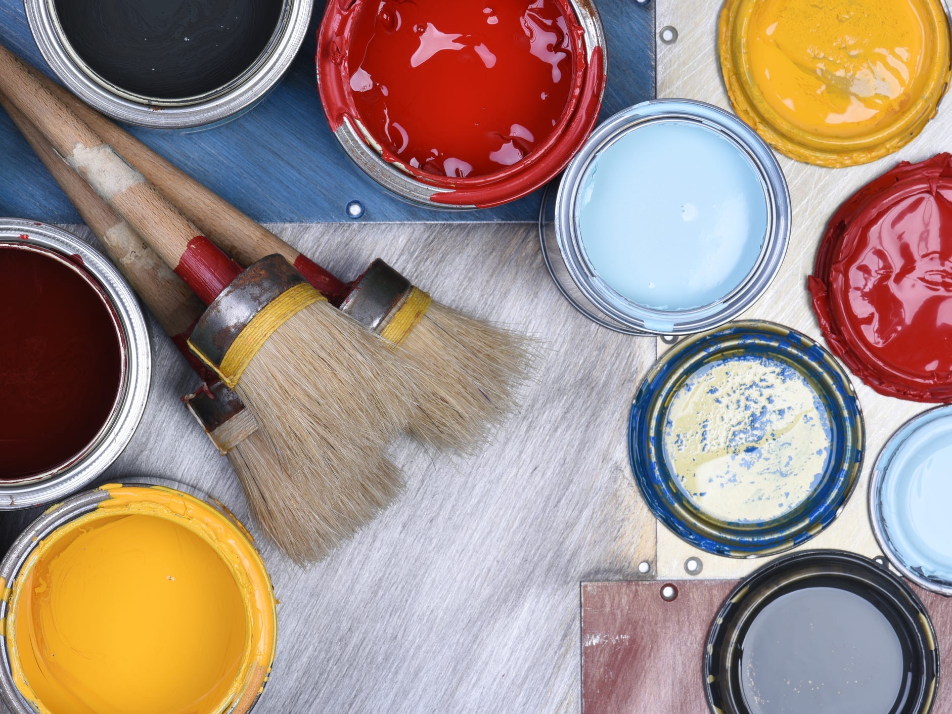 A bunch of paint cans and brushes.