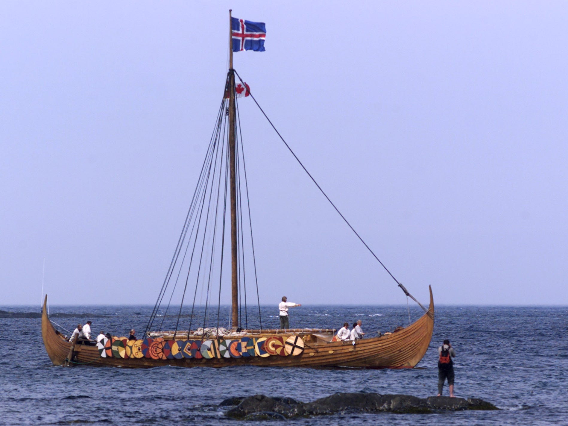 A tourist photographs the Viking replica ship the Islendingur as it arrives in the fishing village of L'Anse aux Meadows in Newfoundland July 28, 2000.