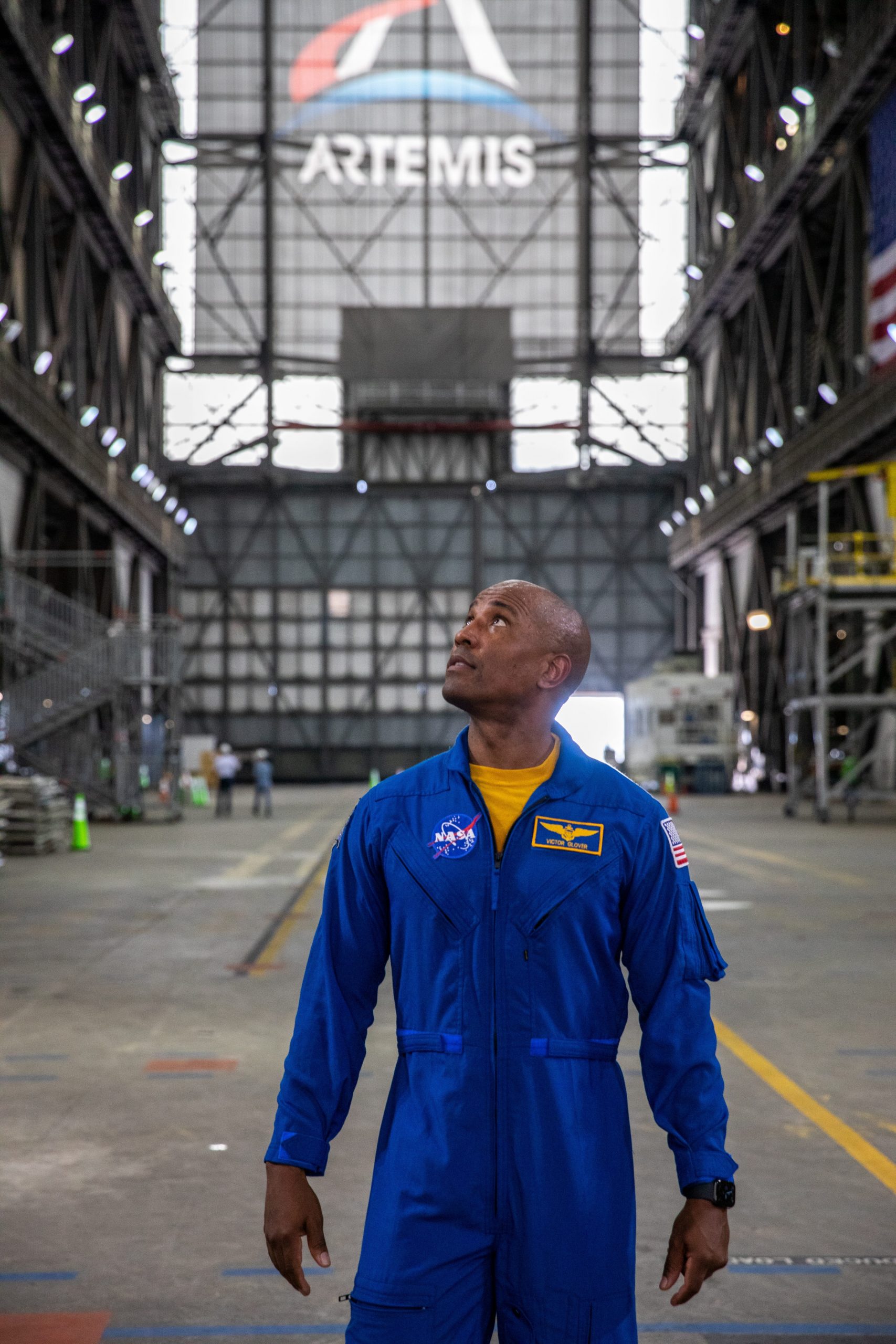 nasa astronaut victor glover looks up inside a rocket assembly building