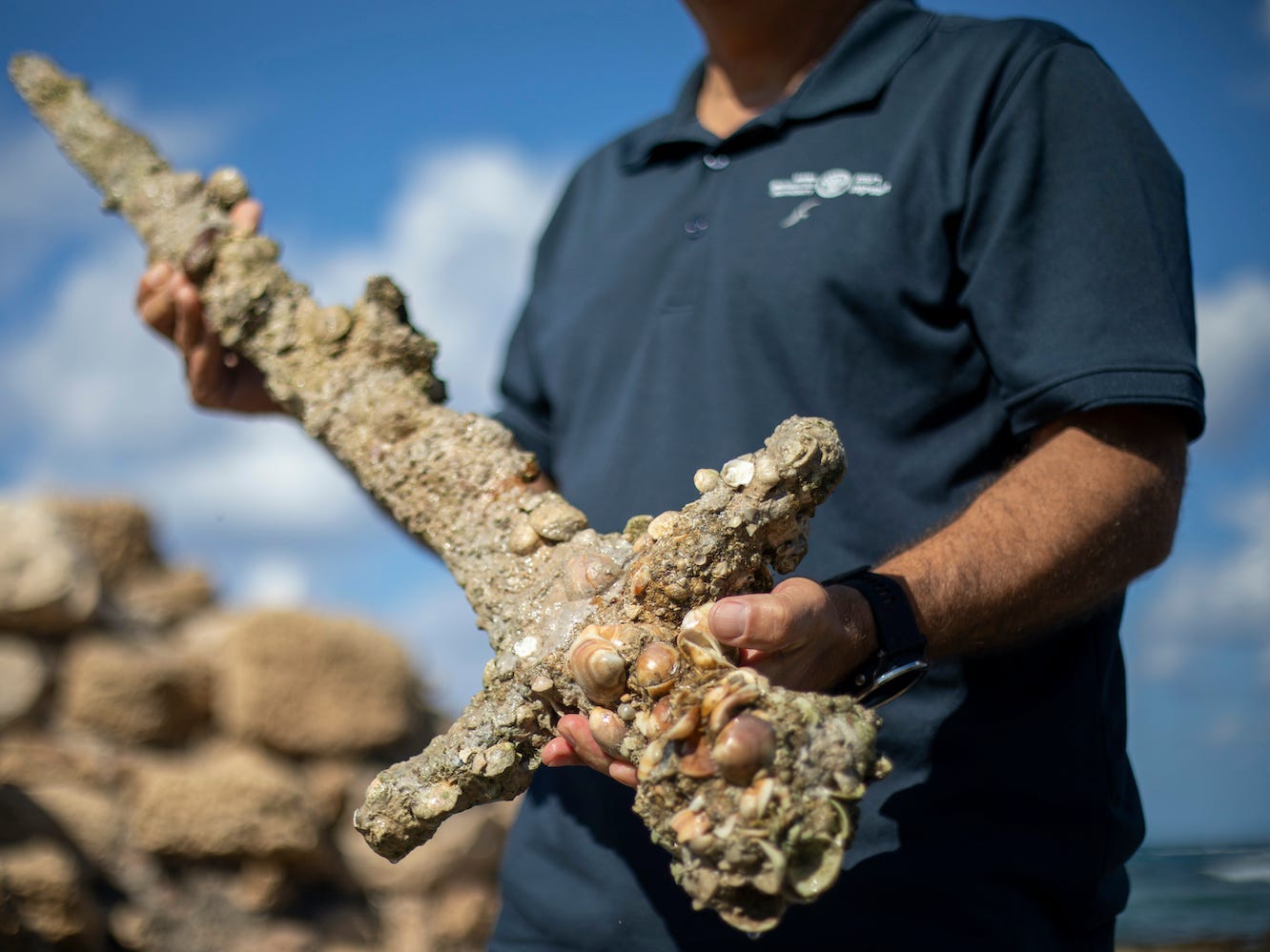 Jacob Sharvit, director of the Marine Archaeology Unit of the Israel Antiquities Authority holds a sword that experts say dates back to the Crusaders.