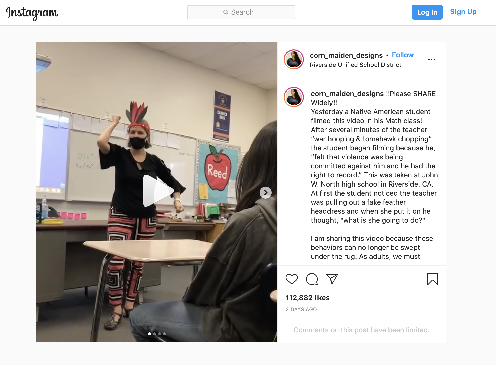 A still from Instagram showing a white woman standing in front of a classroom with a fake headdress.
