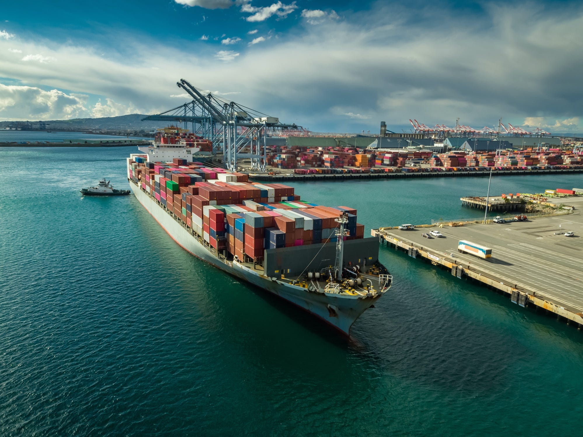 Aerial shot of a massive cargo ship arriving in the Port of Long Beach, California.