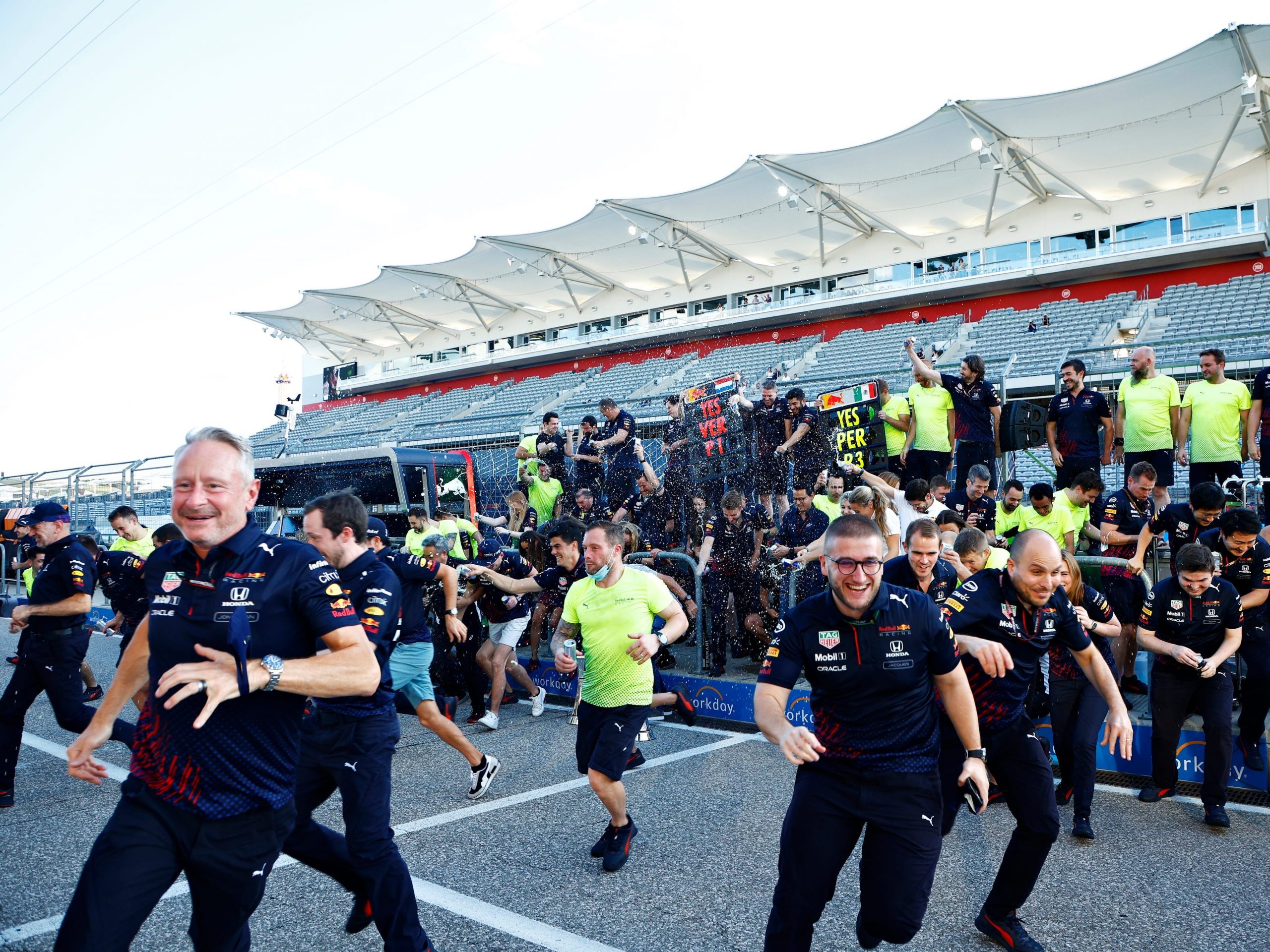 Red Bull staff flee as cans of the energy drink start being sprayed.